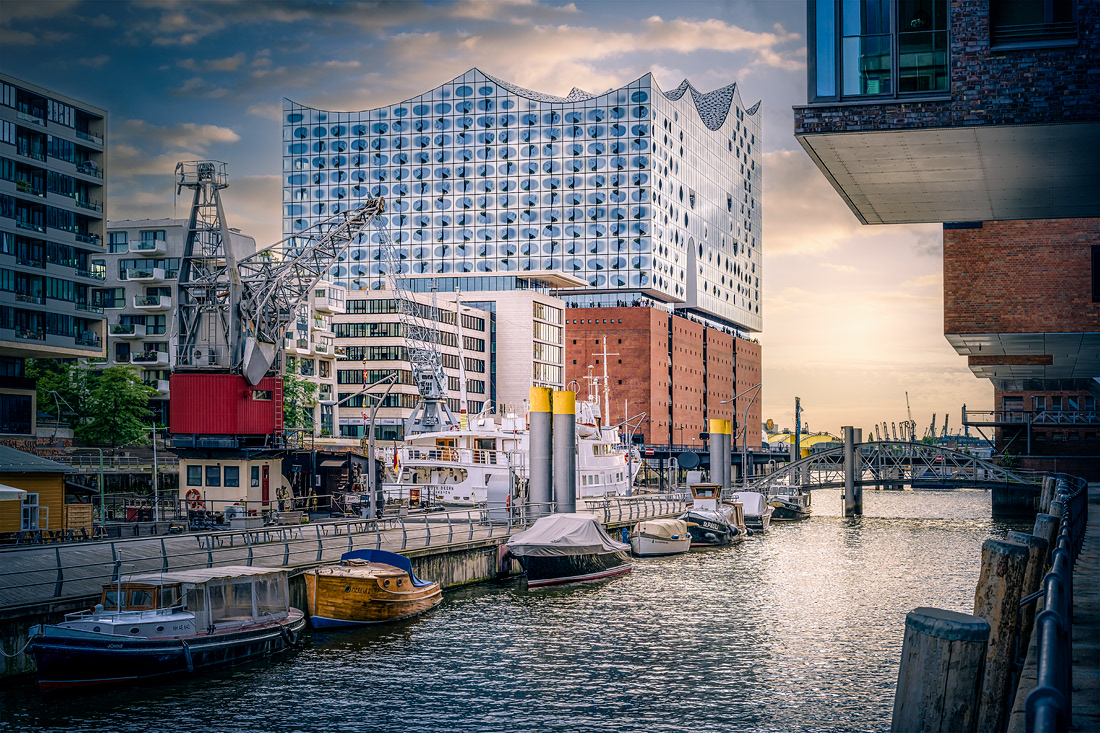 NICOLE HOLZ FOTOGRAFIE | Architektur und Stadtfotografie | Hamburg: im historischen Sandtorhafen mit Ausblick auf die Elbphilharmonie in der HafenCity. Der Sandtorhafen ist der Traditionsschiffhafen der Stiftung Hamburg Maritim. Seit 1866 ist er das erste künstlich geschaffene Hafenbecken Hamburgs, wo Seeschiffe längsseits am Kai liegend abgefertigt werden konnten. Der Sandtorhafen gilt als Keimzeile des „modernen Hafens“. Der Sandtorkai, heute Hamburgs älteste Kaimauer, wurde bereits 2002 denkmalgerecht restauriert und 2008 im September als Traditionsschiffhafen eröffnet. Eine 5.600 qm große, geschwungene Pontonanlage bietet bei 380 m Liegeplätze für ca. 20-25 historische Schiffe, zu besonderen Anlässen können 40-50 Schiffe dort liegen.