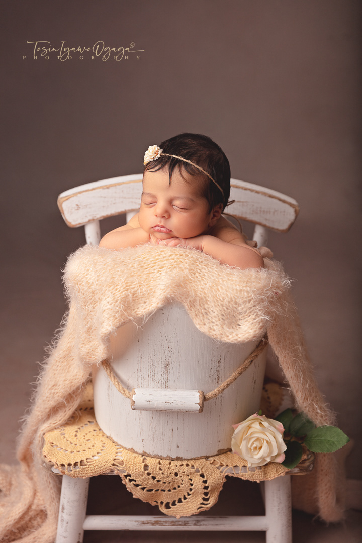 Newborn baby posed in a bucket by TIO Photography