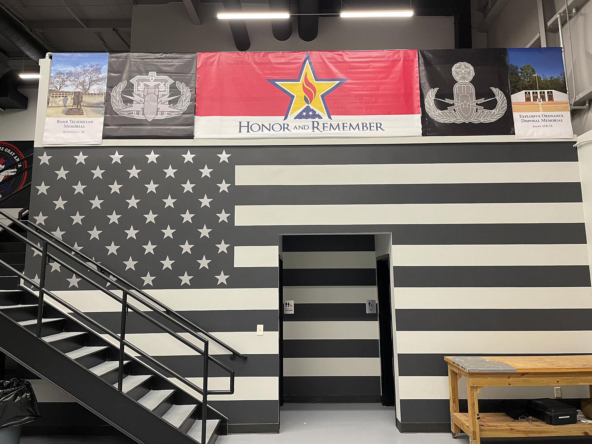 Designed flag wall with star decals and painted stripes mural, and vinyl banners above