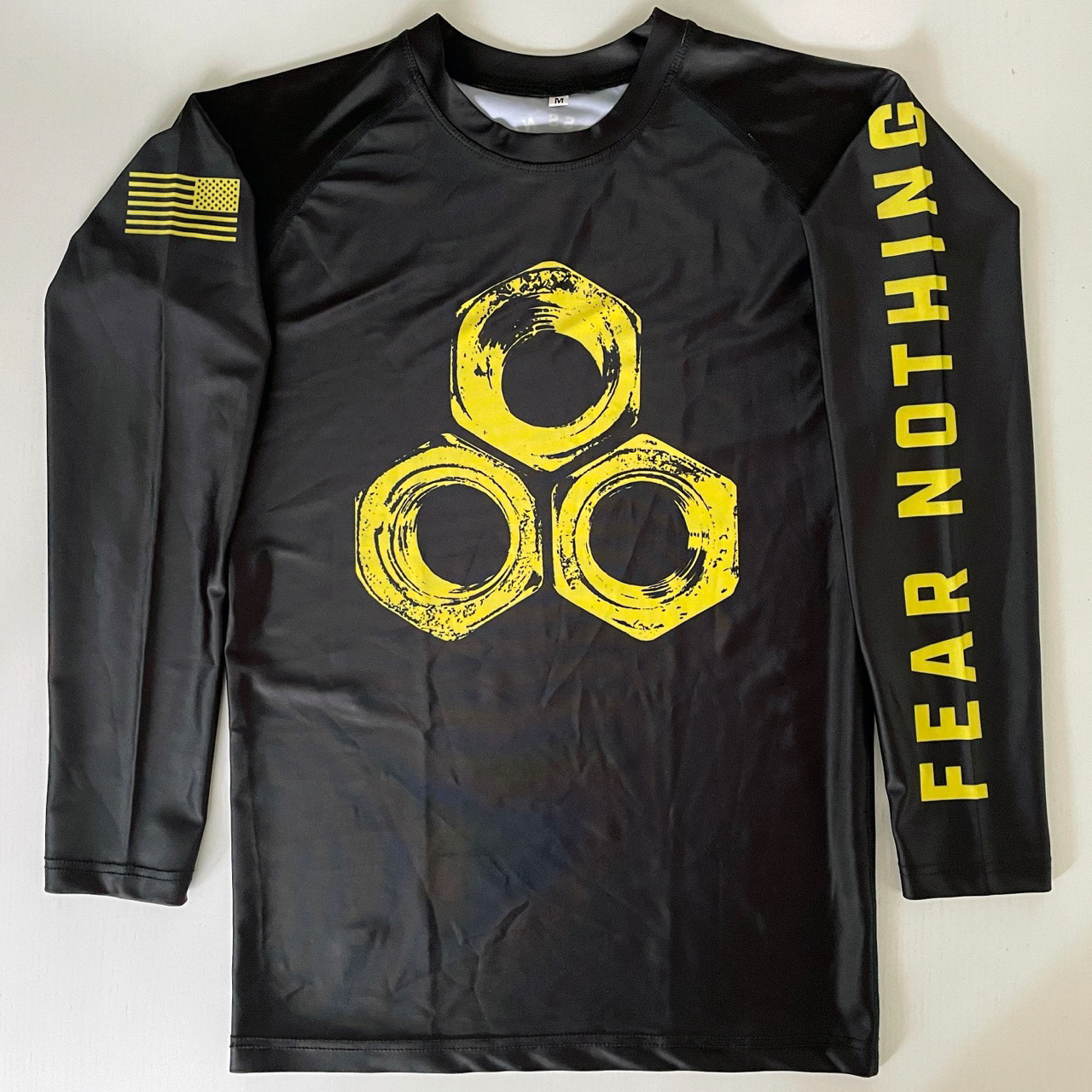 Rash guard when laid flat showing front and sleeve designs