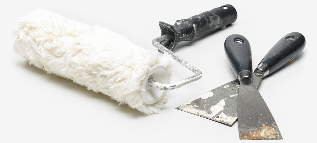 A well-used paint roller and paint scrapers. 