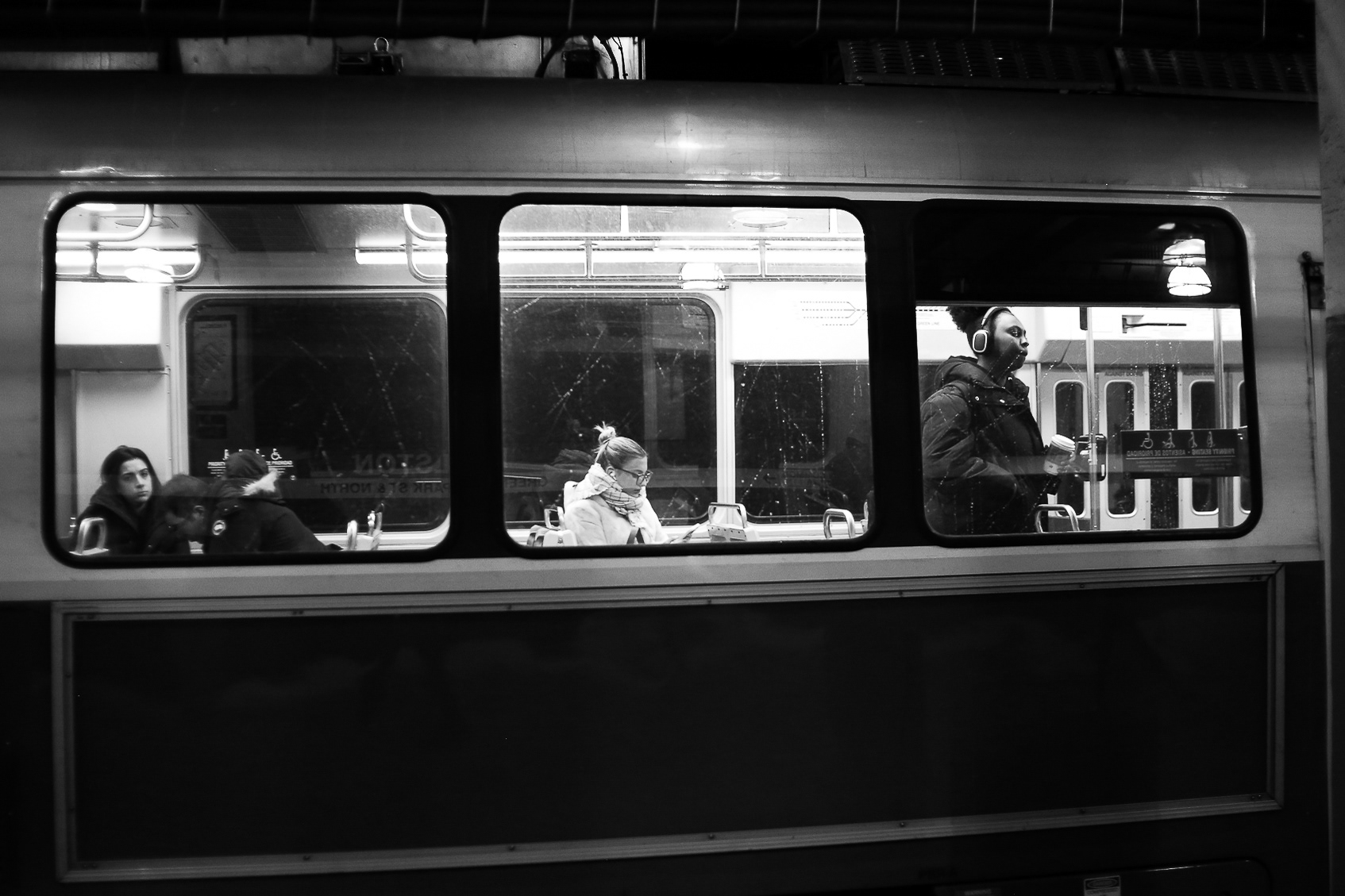 Passengers standing and sitting on the green line patiently wait for the train to move, the train sitting at the Boylstop stop on its way to Park Street; February 8th, 2025.