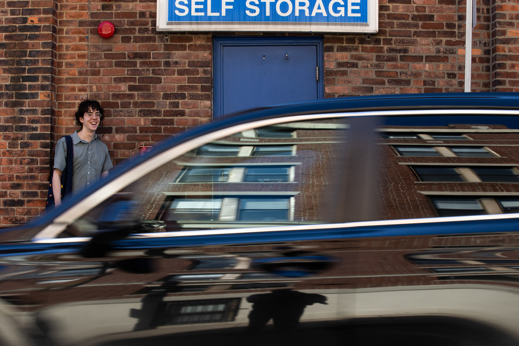 As a car gets in the way of Lucas Dantas Leite's photo, they can't help but laugh and just let the driver pass on by; March 9th, 2026.