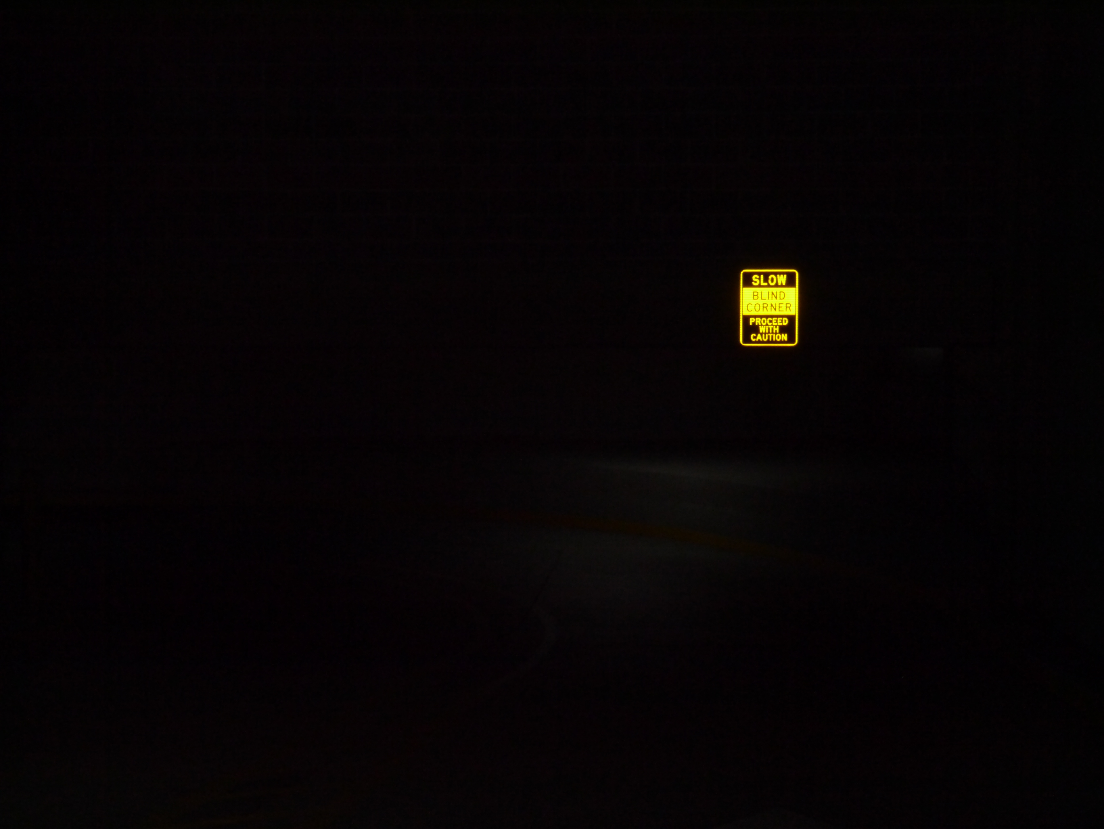 An illuminated yellow sign inside a parking garage near Union Station; December 31st, 2023.
