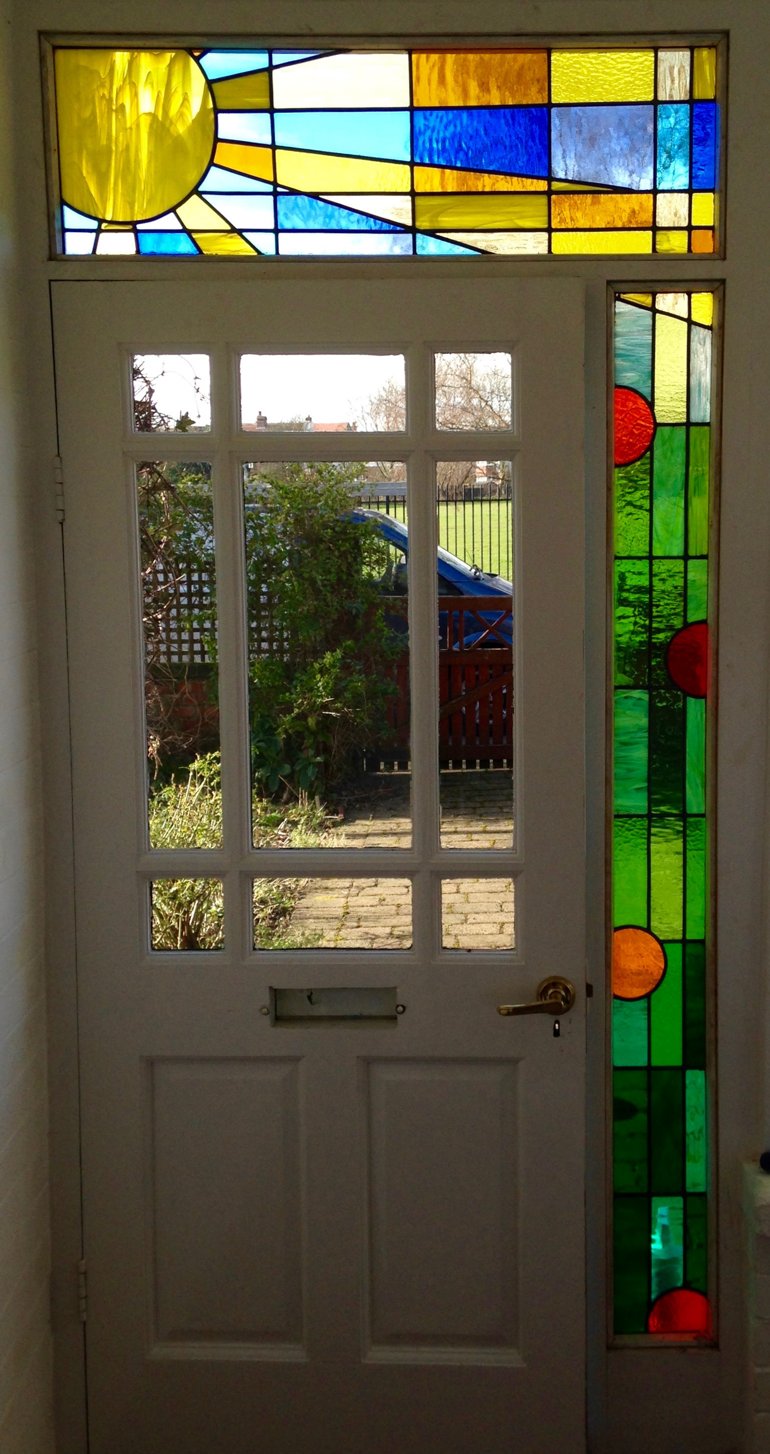 Stained glass in Headingley Leeds. Original Clarice Cliff themed design in art glass. Sunshine, sunbeams with abstract nasturtiums - seen from the inside.