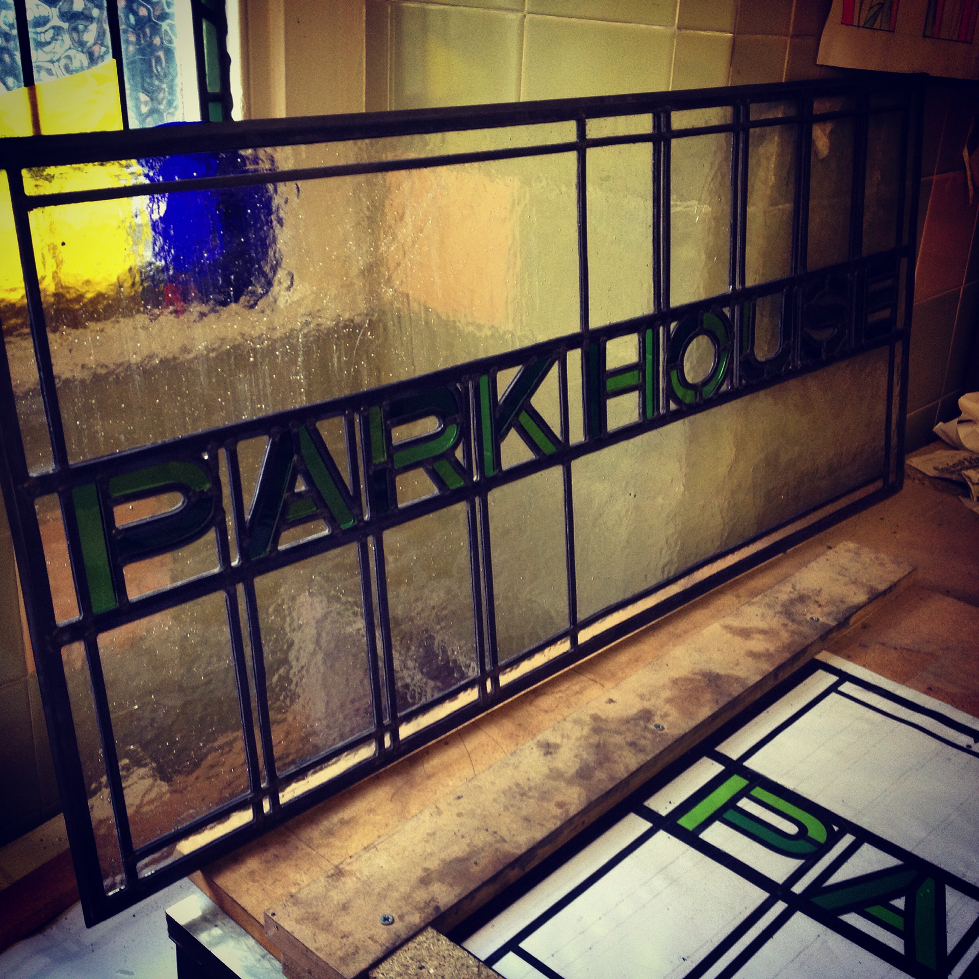 Traditional Stained Glass and art glass encapsulated panel using Art Nouveau theme by Zoe Eady of The Glass Garden. Park House text viewed under construction in the studio