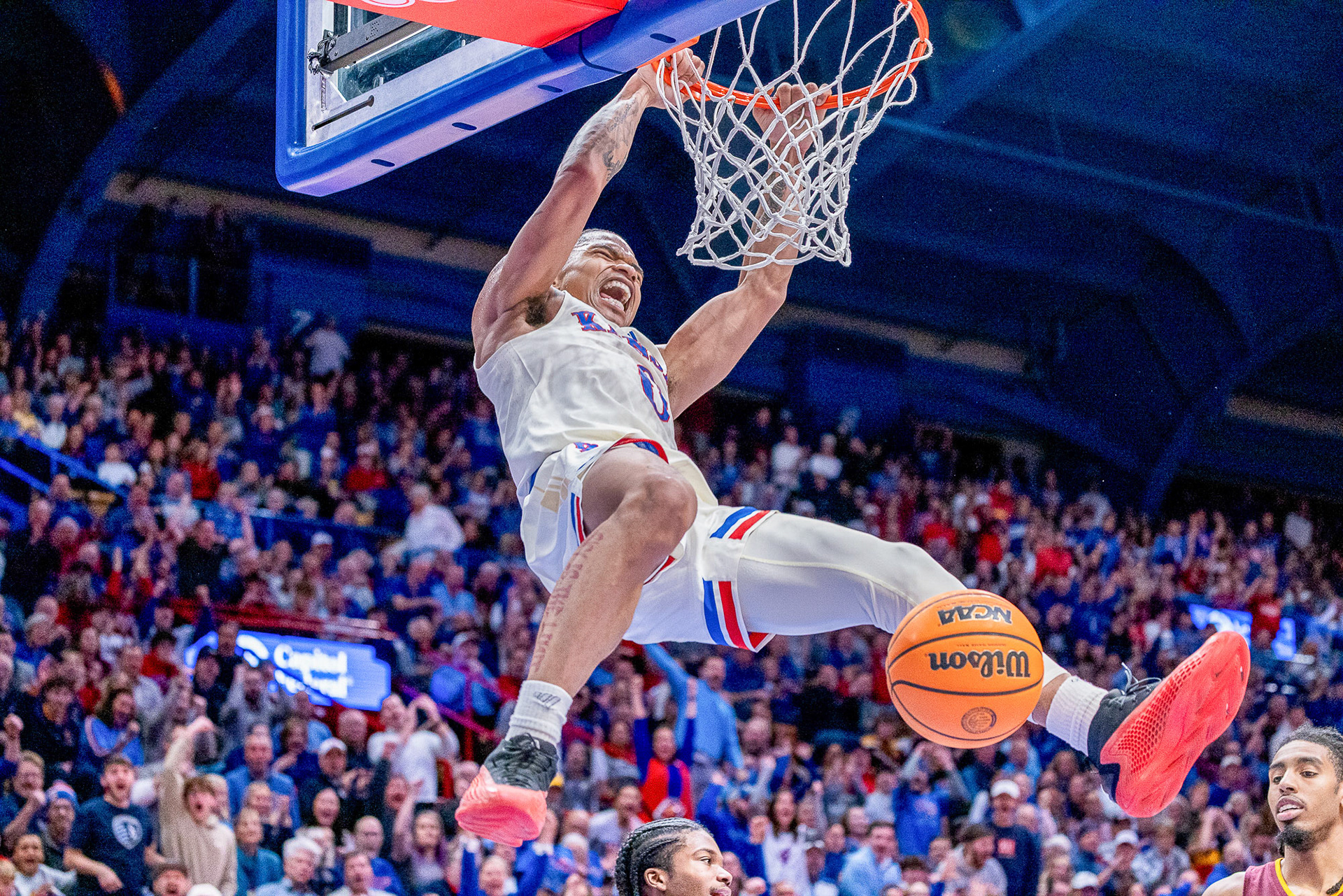 KU guard Shakeel Moore hangs on the rim and yells after throwing down a dunk on Arizona State on Wednesday, Jan. 8, 2025, at Allen Fieldhouse in Lawrence, Kan.