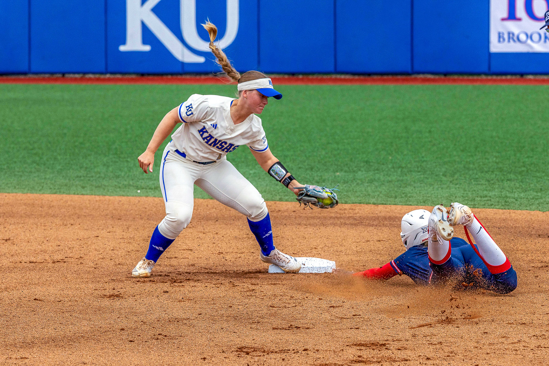 KU senior Sara Roszak attempts to lay down a tag on Arizona's Dakota Kennedy as she slides safely into second base on Sunday, April 13, 2025, at Arrocha Ballpark in Lawrence, Kan.