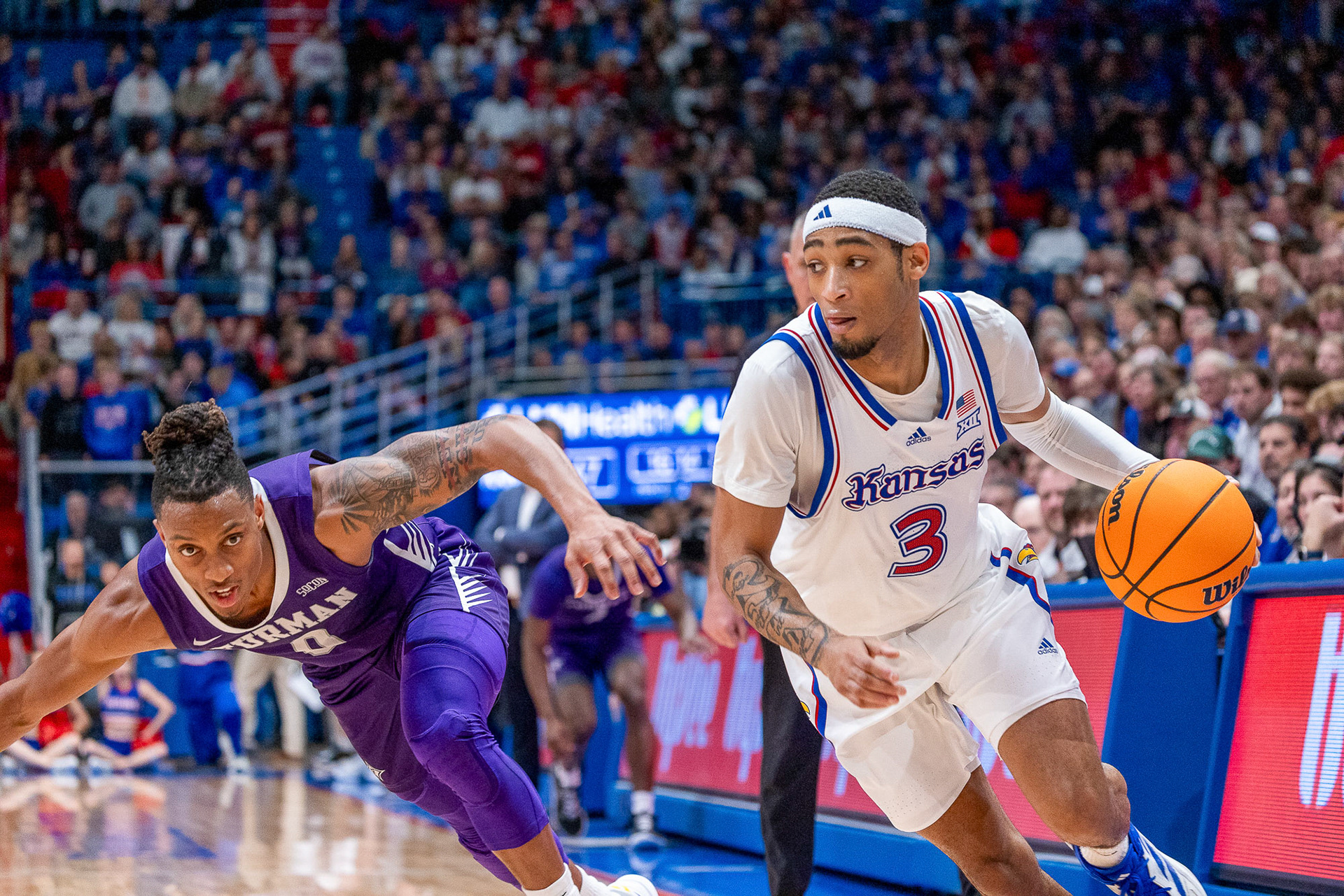 KU guard Dajuan Harris blows past Furman’s PJay Smith Jr. on Saturday, Nov. 30, 2024, at Allen Fieldhouse in Lawrence, Kan.