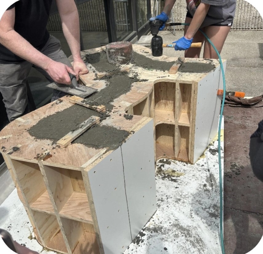 Concrete chair: Post concrete pour, breaking up air bubbles and smoothing surface layer.