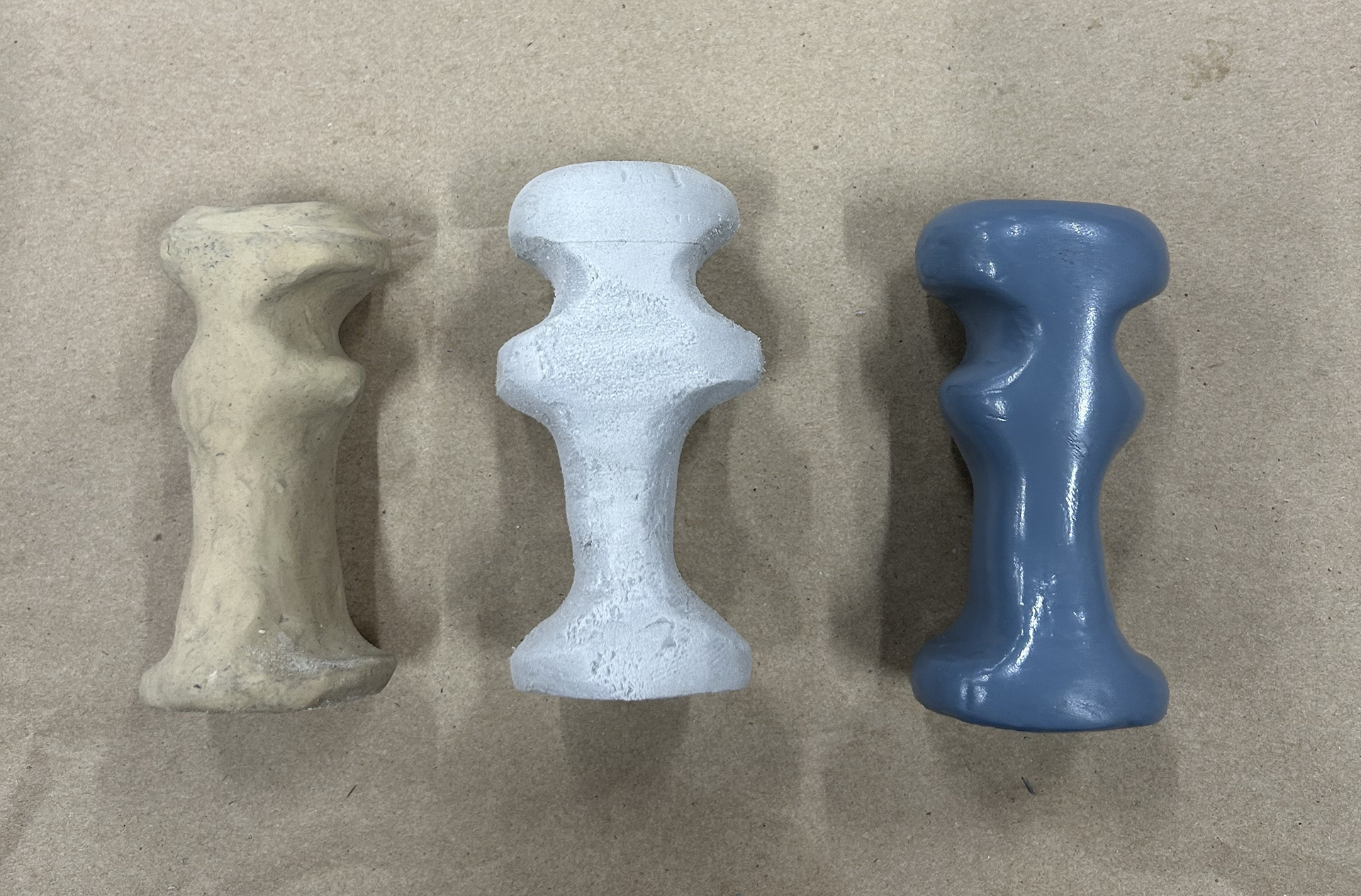 From left to right: initial clay model, refined foam prototype, and final sealed form. The design evolved through hands-on iteration, transitioning from sculpting to precise carving and refinement.