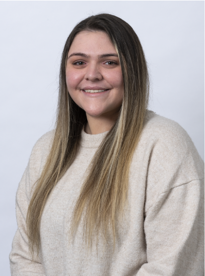 Breanna Kerr, smiling in a white sweater in front of a solid light-blue background.
