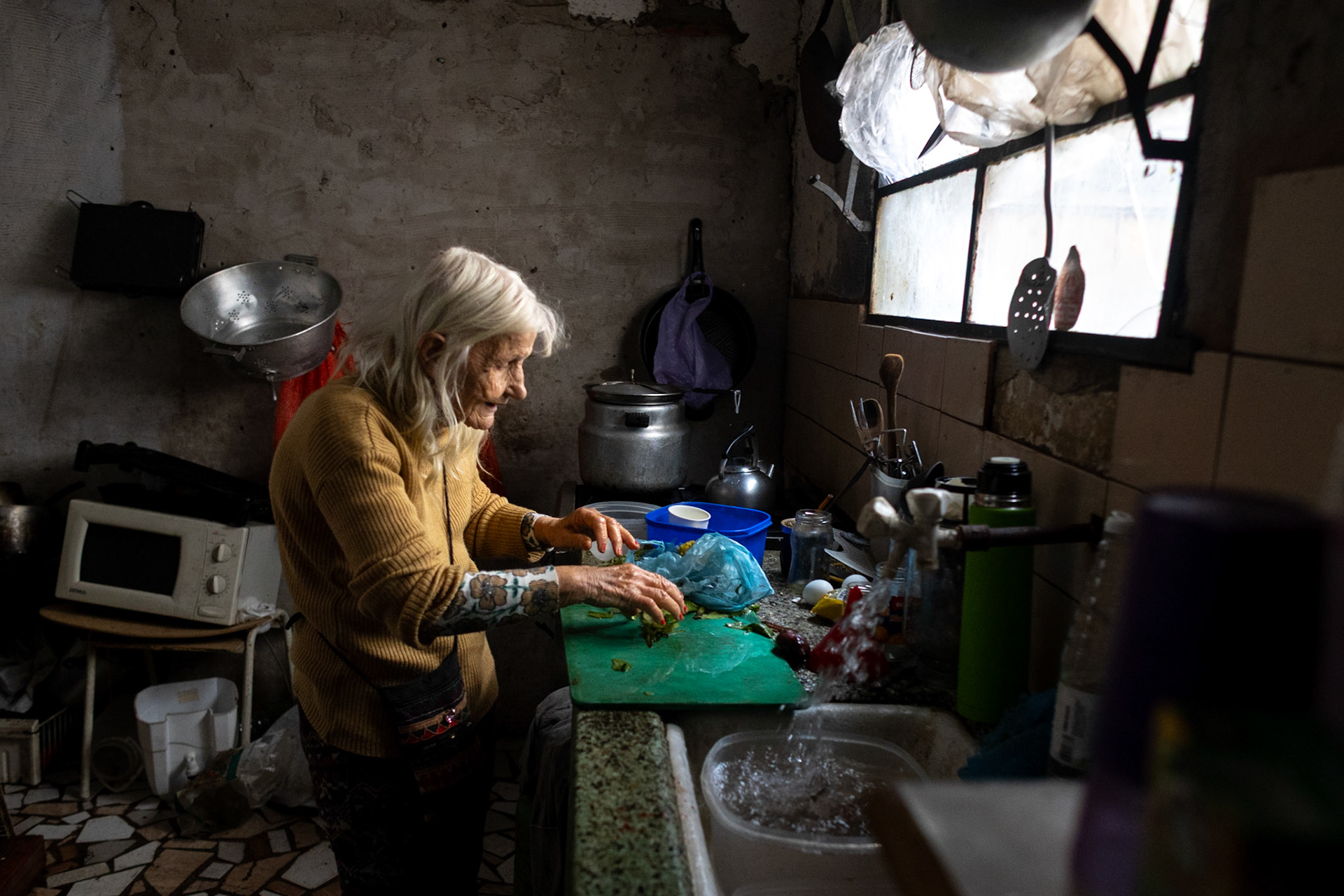 Retiree Olga González prepares a meal at her home using vegetables she salvaged from the street | Buenos Aires, 2025