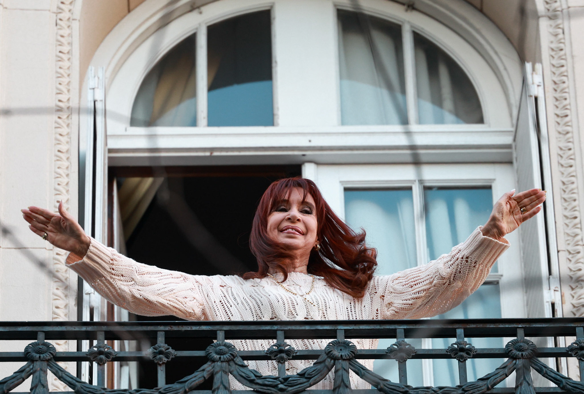 Cristina Fernández de Kirchner greets supporters from the balcony of her home on her first day under house arrest following her conviction in the “Vialidad” corruption case | Buenos Aires, 2025.