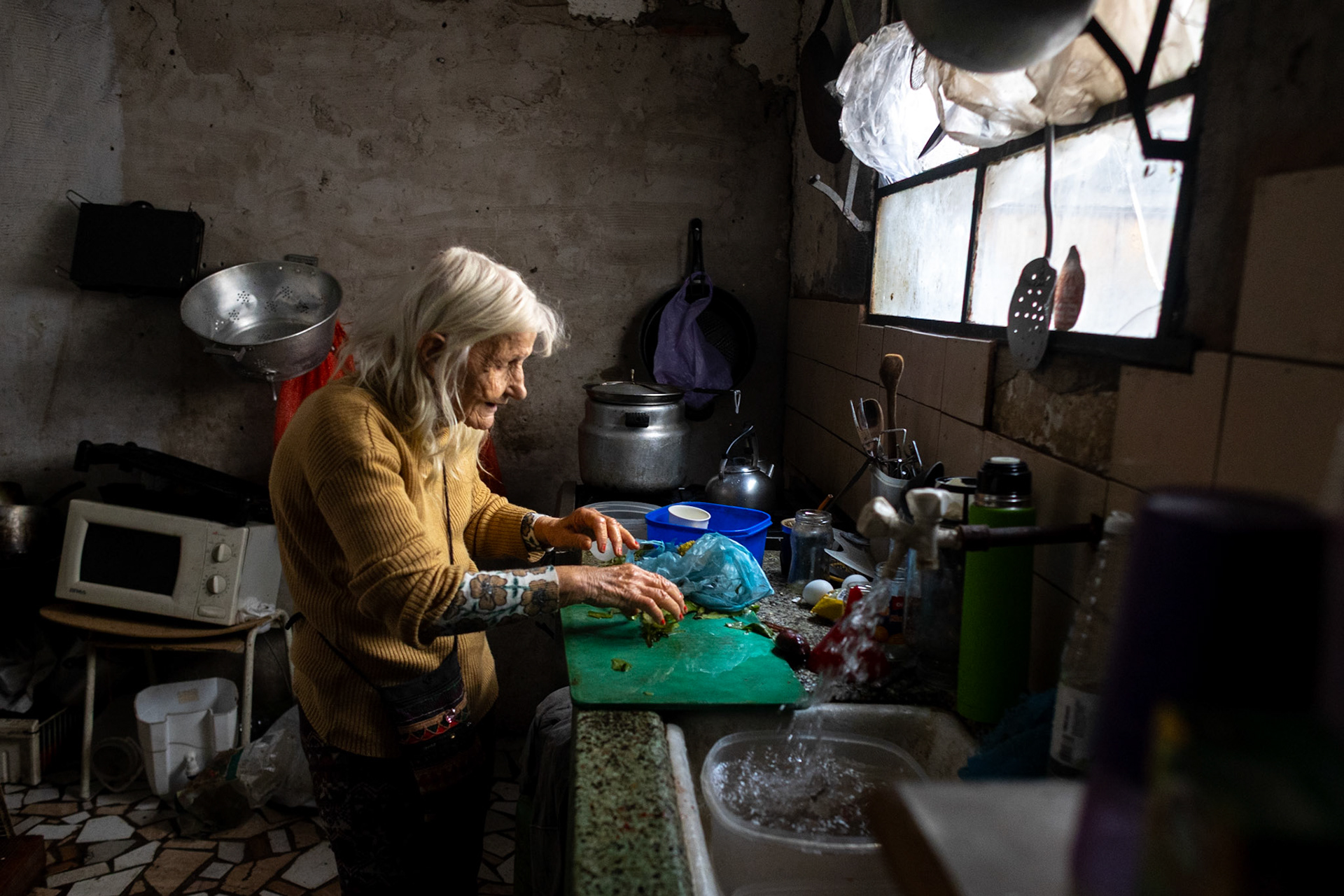 Retiree Olga González prepares a meal at her home using vegetables she salvaged from the street | Buenos Aires, 2025
