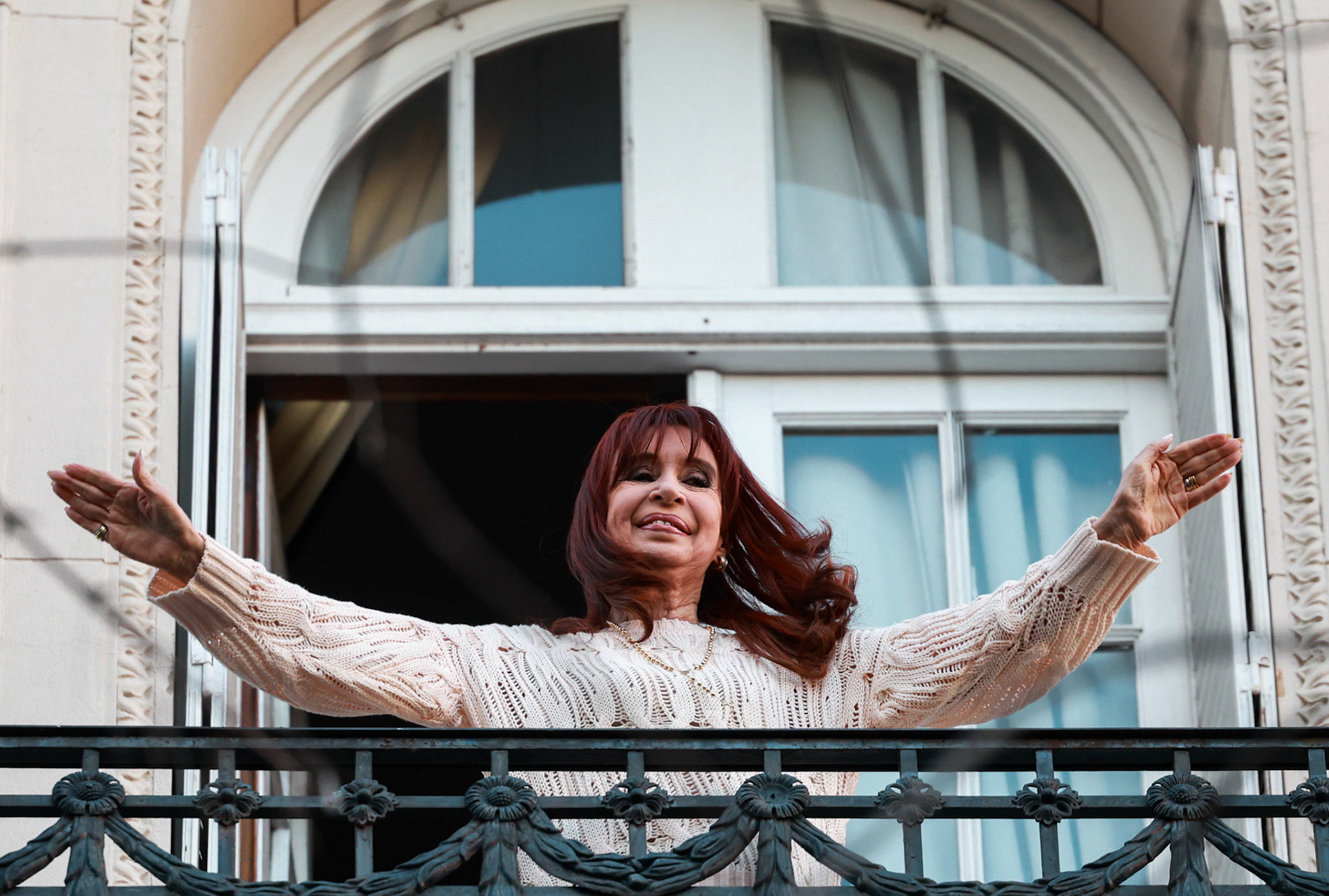 Former president Cristina Fernández de Kirchner greets supporters from the balcony of her home on her first day under house arrest following her conviction in the “Vialidad” corruption case | Buenos Aires, 2025.