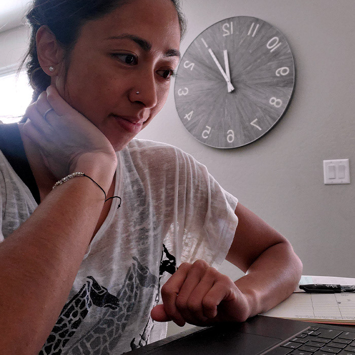 ABBracher working at computer with clock in background