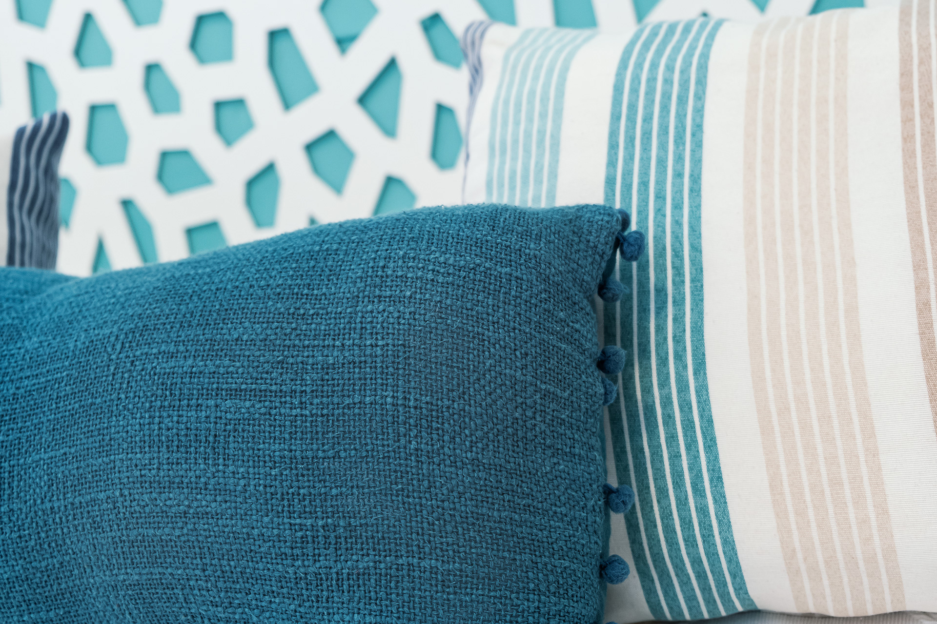 Detalle de cabecera de cama y textiles en dormitorio con luz natural en vivienda vacacional en Gran Canaria