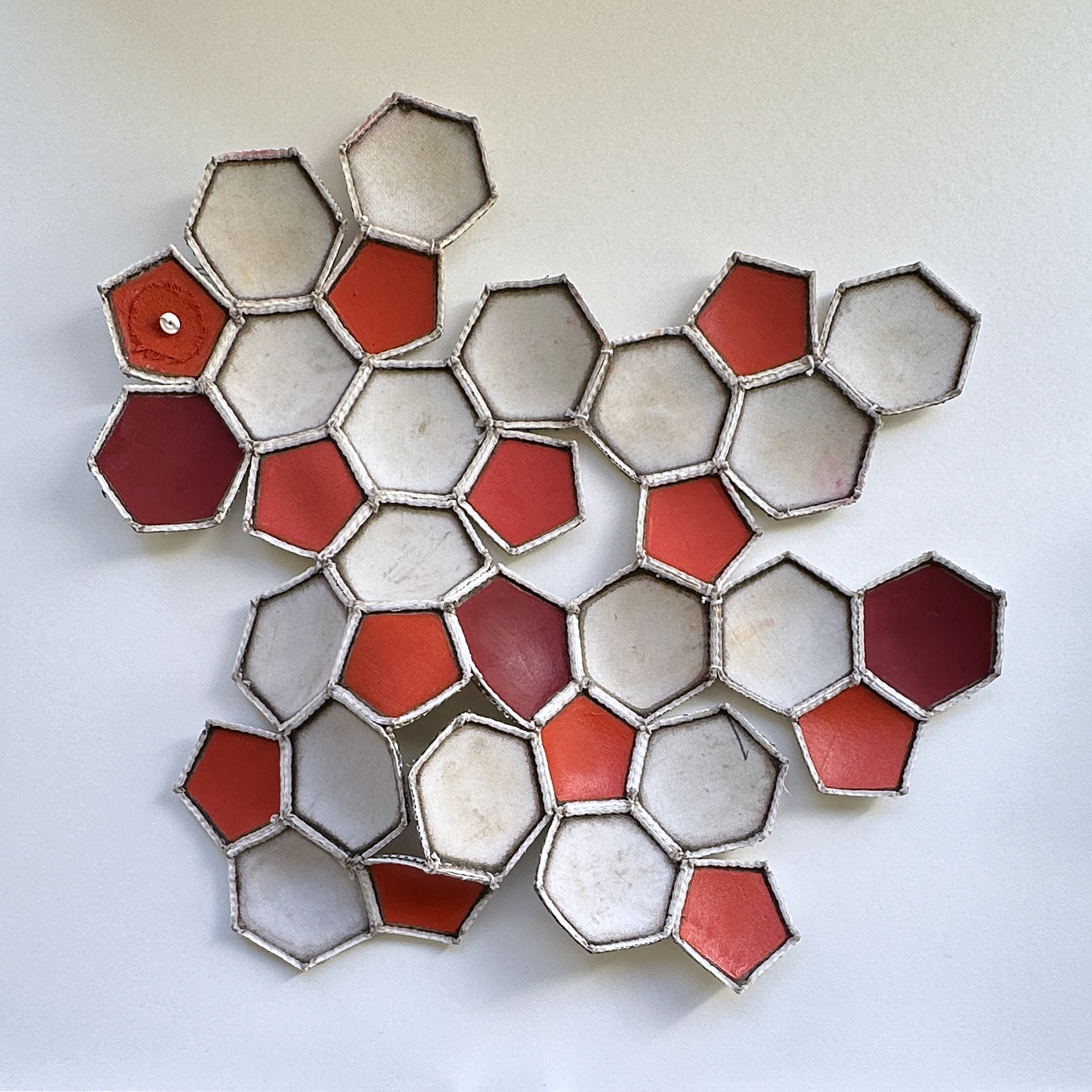 Tessellation #5; dysected soccer ball, thread, new seams, acrylic and oil paint, 2023