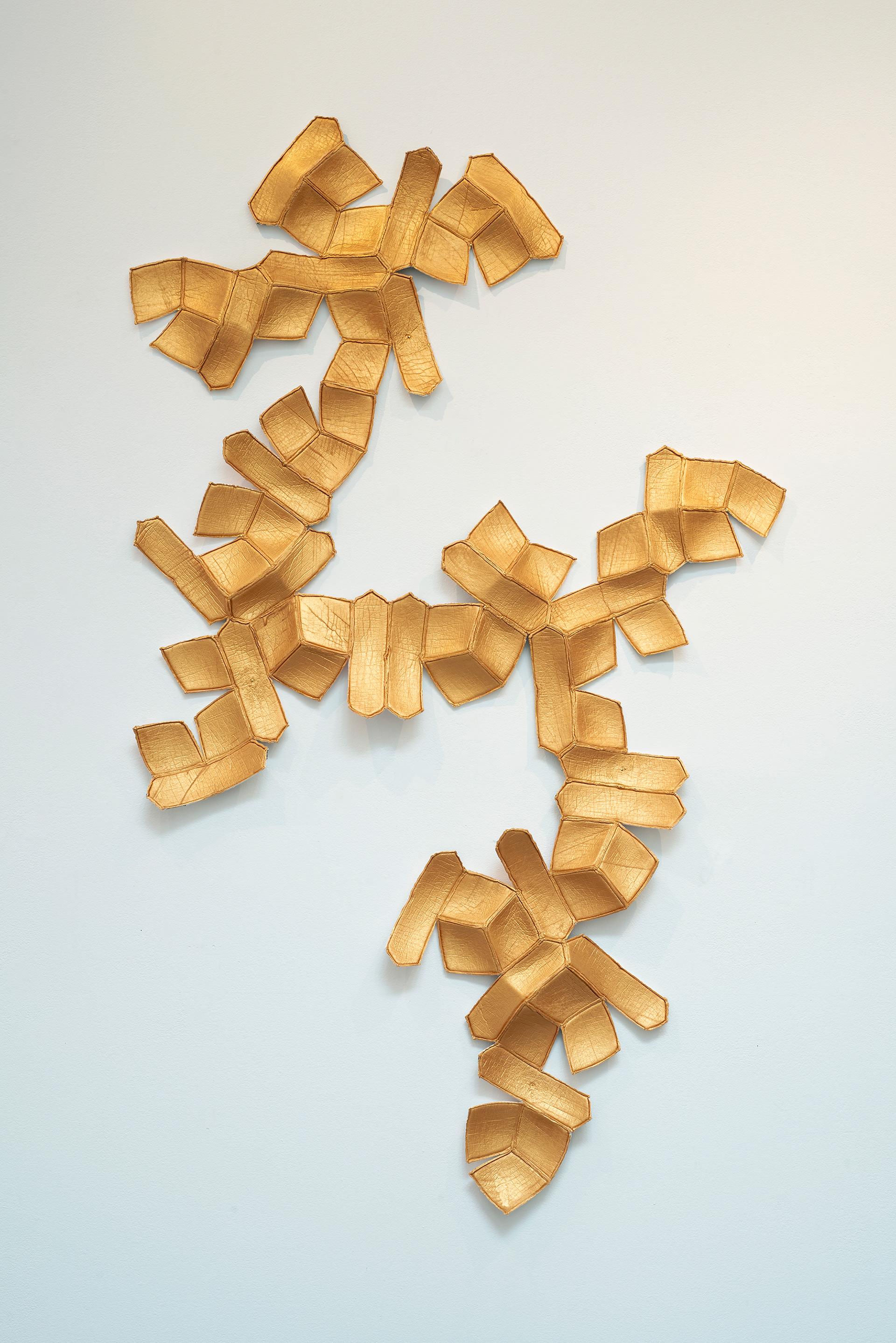 Going for Gold # 10, 2025, Four deconstructed soccer balls, acrylic gold paint,  59” x 38” x 2”  thread, new hand-sewn seams