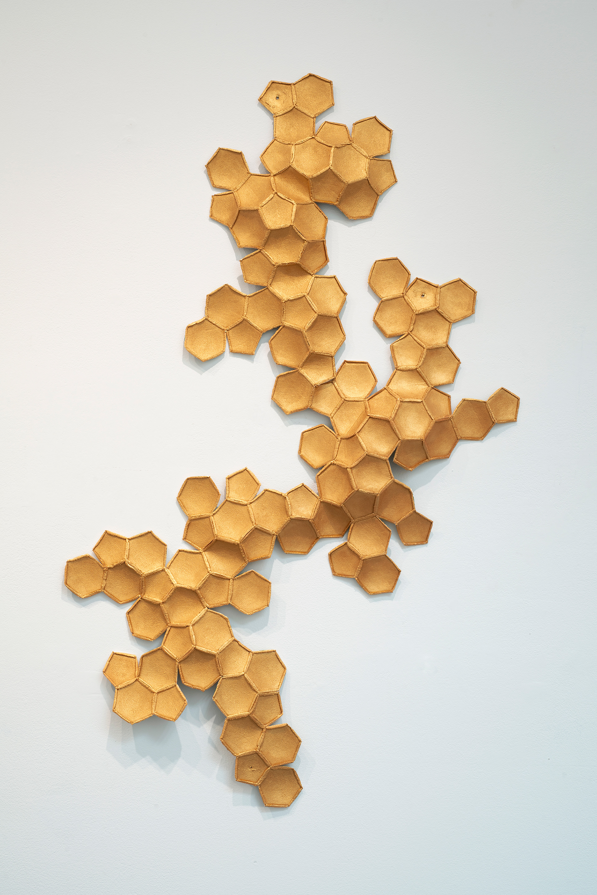 Going for Gold # 9, 2024, Three deconstructed soccer balls, acrylic gold paint,  thread, new hand-sewn seams, 55” x 36” x 3”