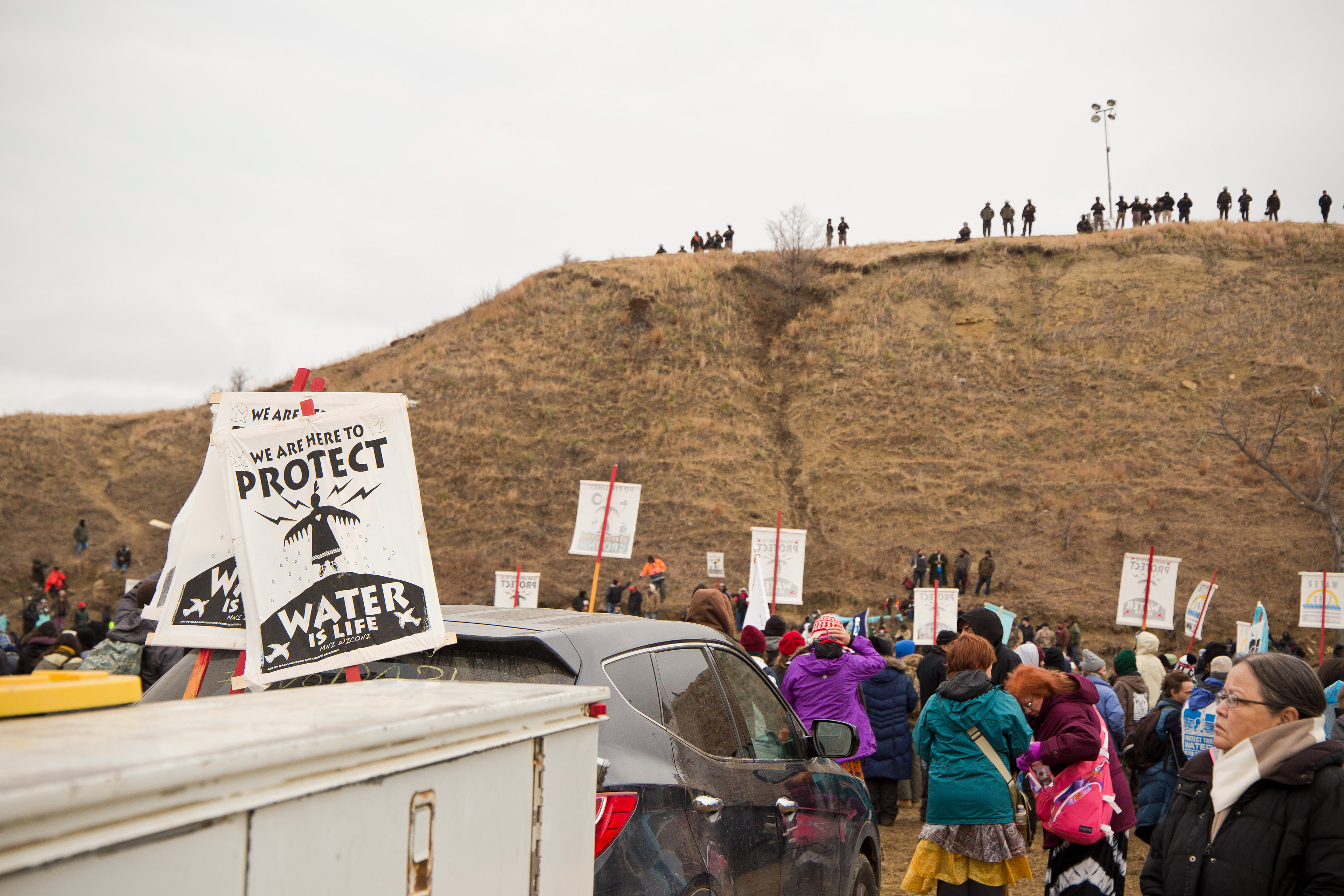 Militarized police peer down from their perch on a sacred burial ground. 