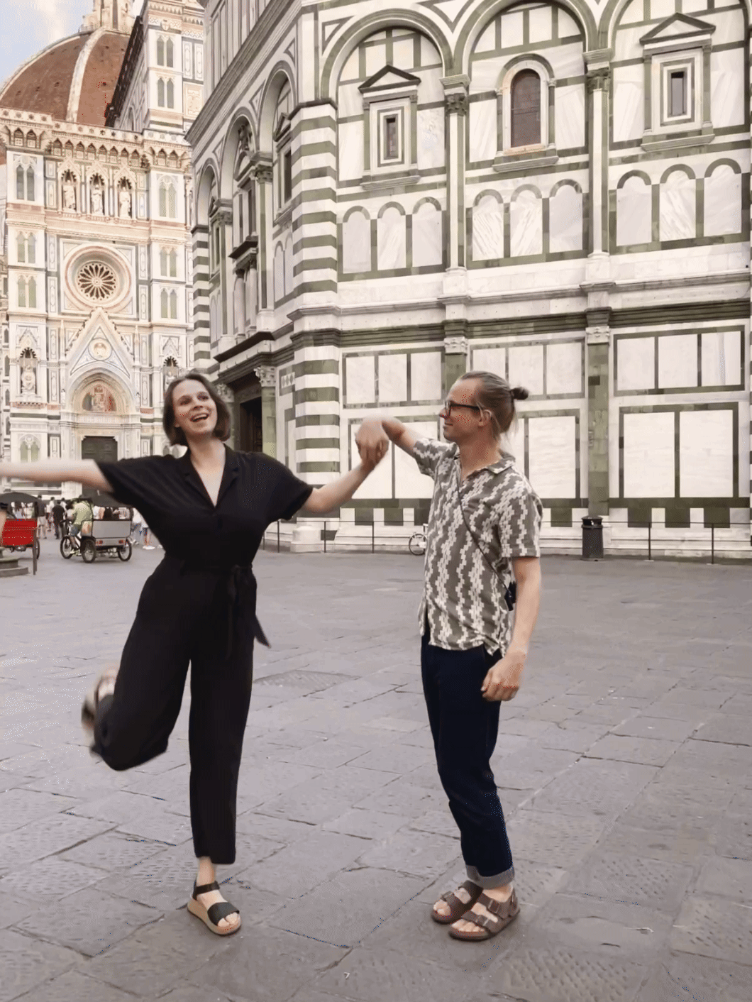 Ein bewegtes Bild von Silas, dem Fotografen dieser Seite und Rahel, seiner Freundin. Sie stehen beide in Florenz und werfen die Arme in die Luft. Beide tragen Birkenstock und freuen sich im Urlaub zu sein.