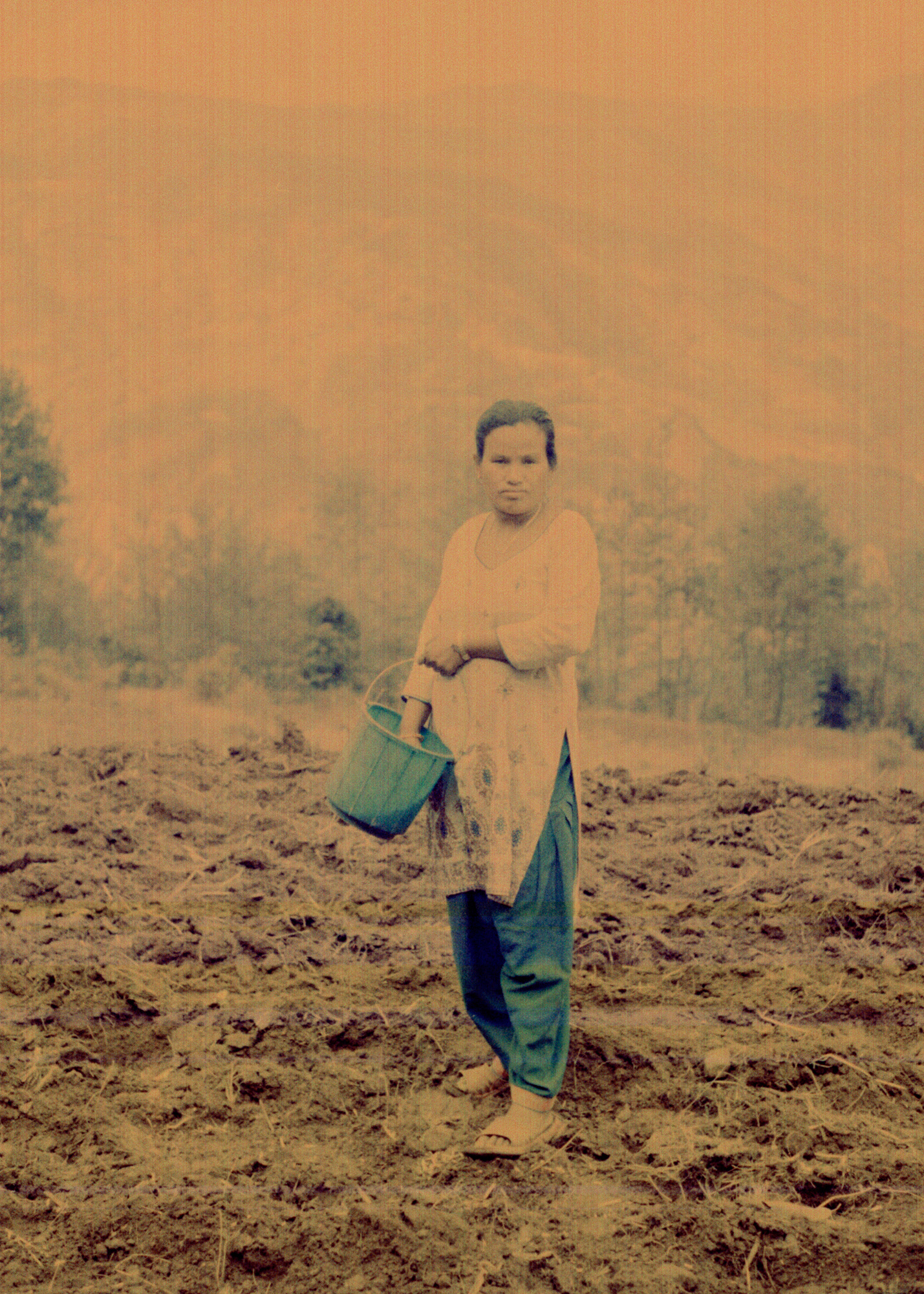 Basanti Jirel (33) planting corn in the hills of Bungathali, where she has lived all her life. Her husband is working as a driver in Saudi Arabia.
