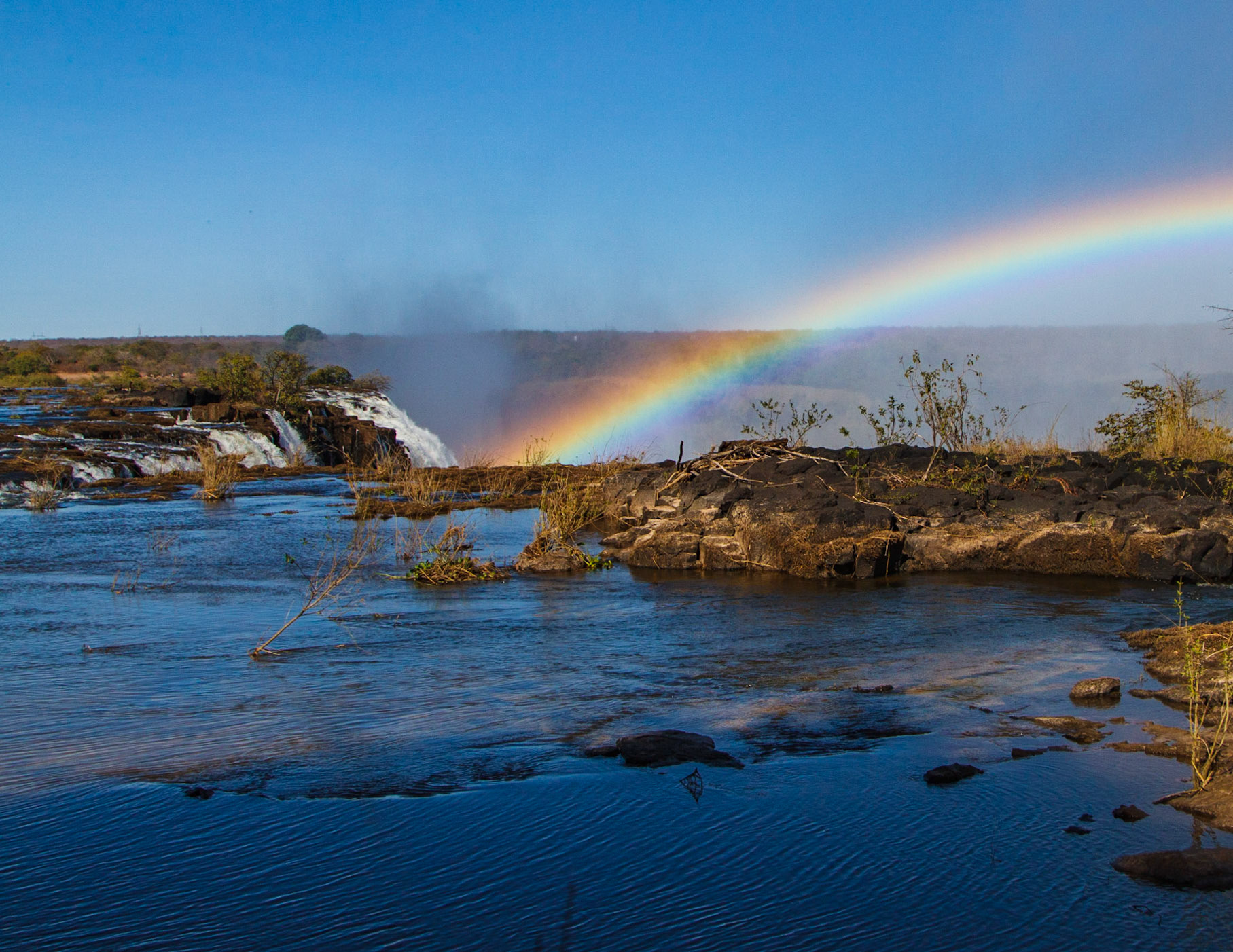 Victoria Falls ,  or  Mosi-Oa-Tunya, Smoke that Thunders,  and Livingstone Island. David Livingstone, the Scottish missionary and explorer, is believed to have been the first European to view Victoria Falls on 16 November 1855 from what is now known as Livingstone Island, one of two land masses in the middle of the river, immediately upstream from the falls on the Zambian side.  While it is neither the highest nor the widest waterfall in the world, it is claimed to be the largest. This claim is based on a width of 1,708 metres (5,604 ft) and height of 108 metres (354 ft), forming the largest sheet of falling water in the world.