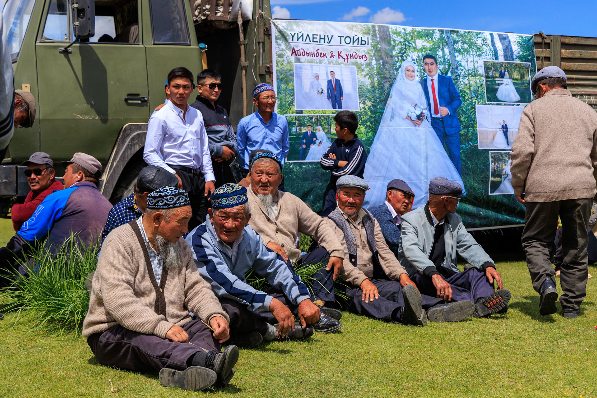 Respected elder men, picture of bride and groom in backgound