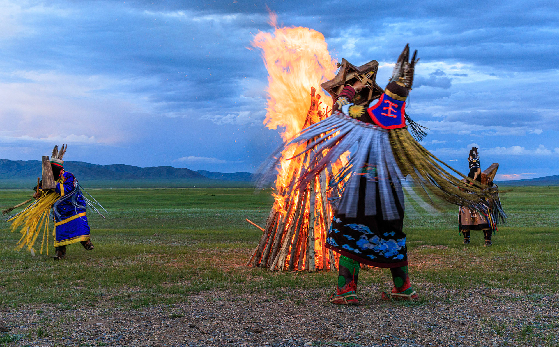 Mongolian Shaman invoking spirits of ancestors at traditional sunset fireside ceremony