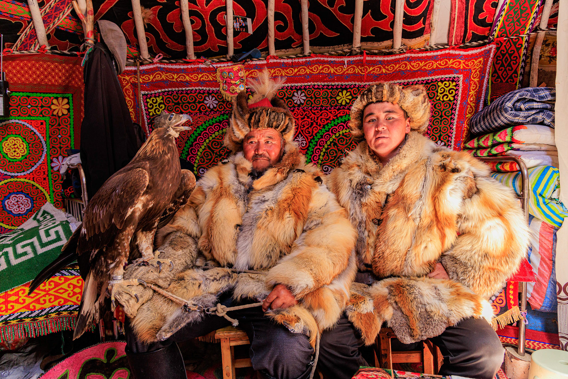 Kazakh Eagle Hunters Sailua and Serikjan, dressed for the hunt,  with Golden Eagle 