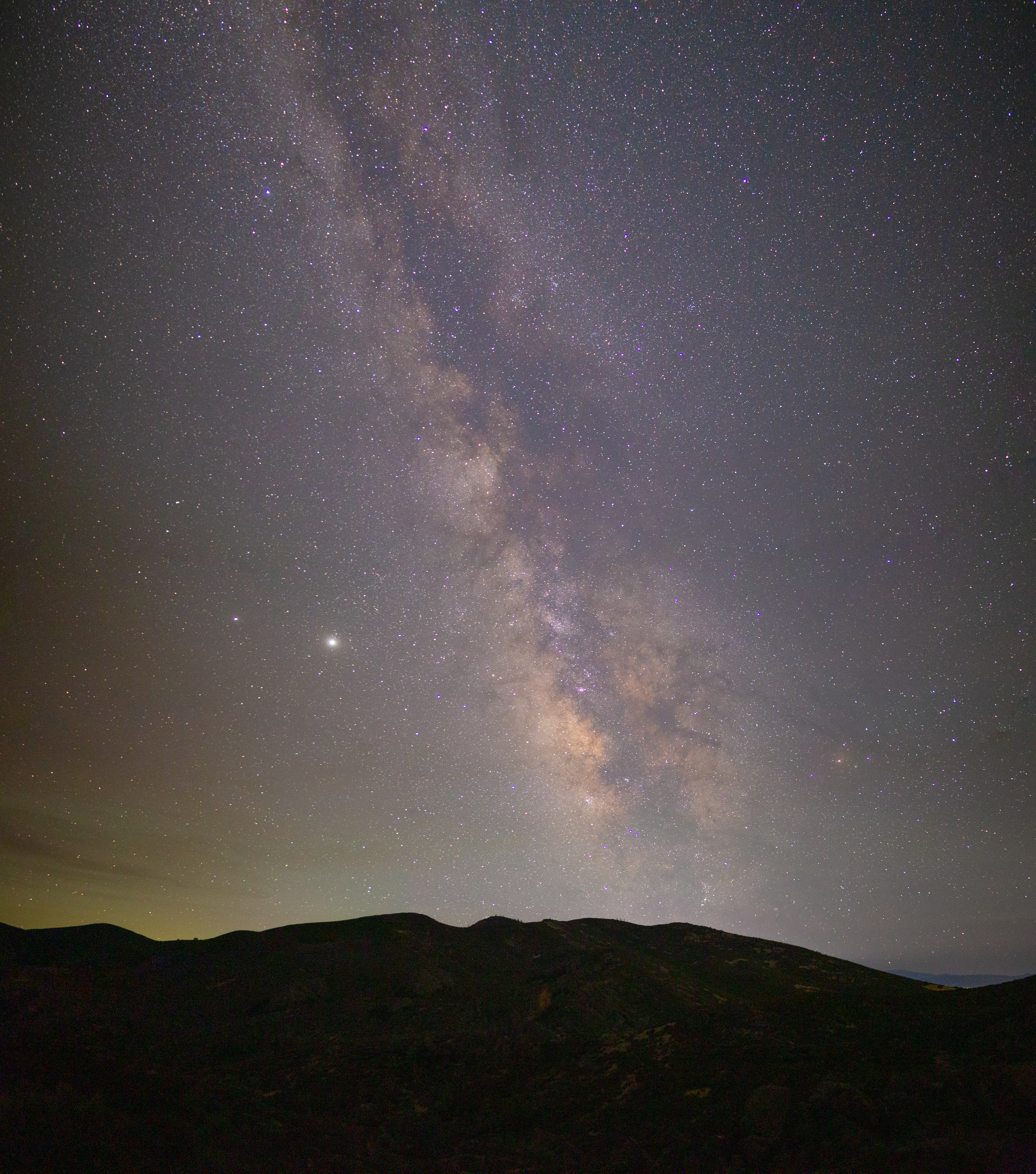 Jupiter and Saturn float together next to the core of the milky way over Pinnacles NP, CA.