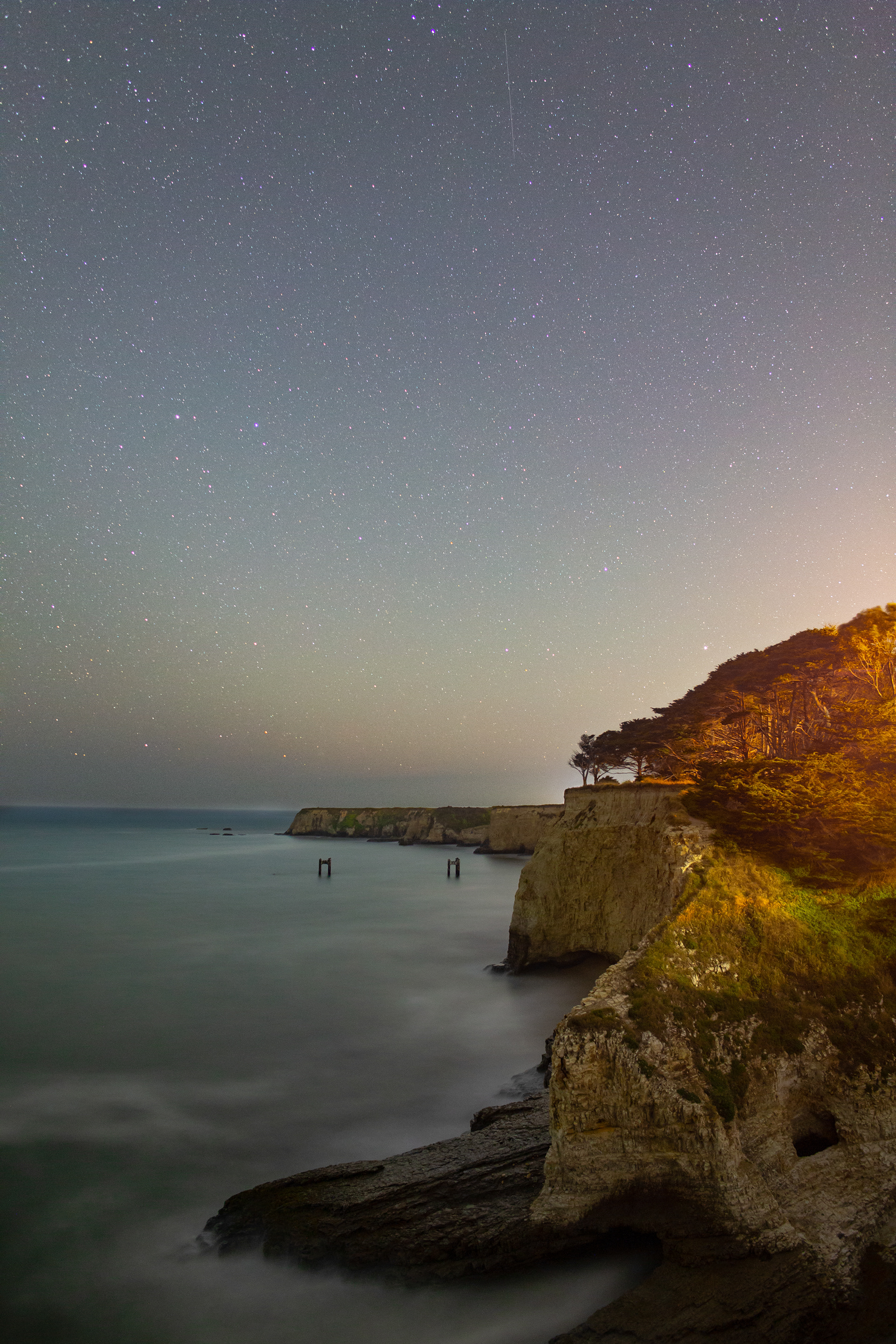 The California Coast shows off its dark skies over the remnants of an old pier in Davenport, CA.
