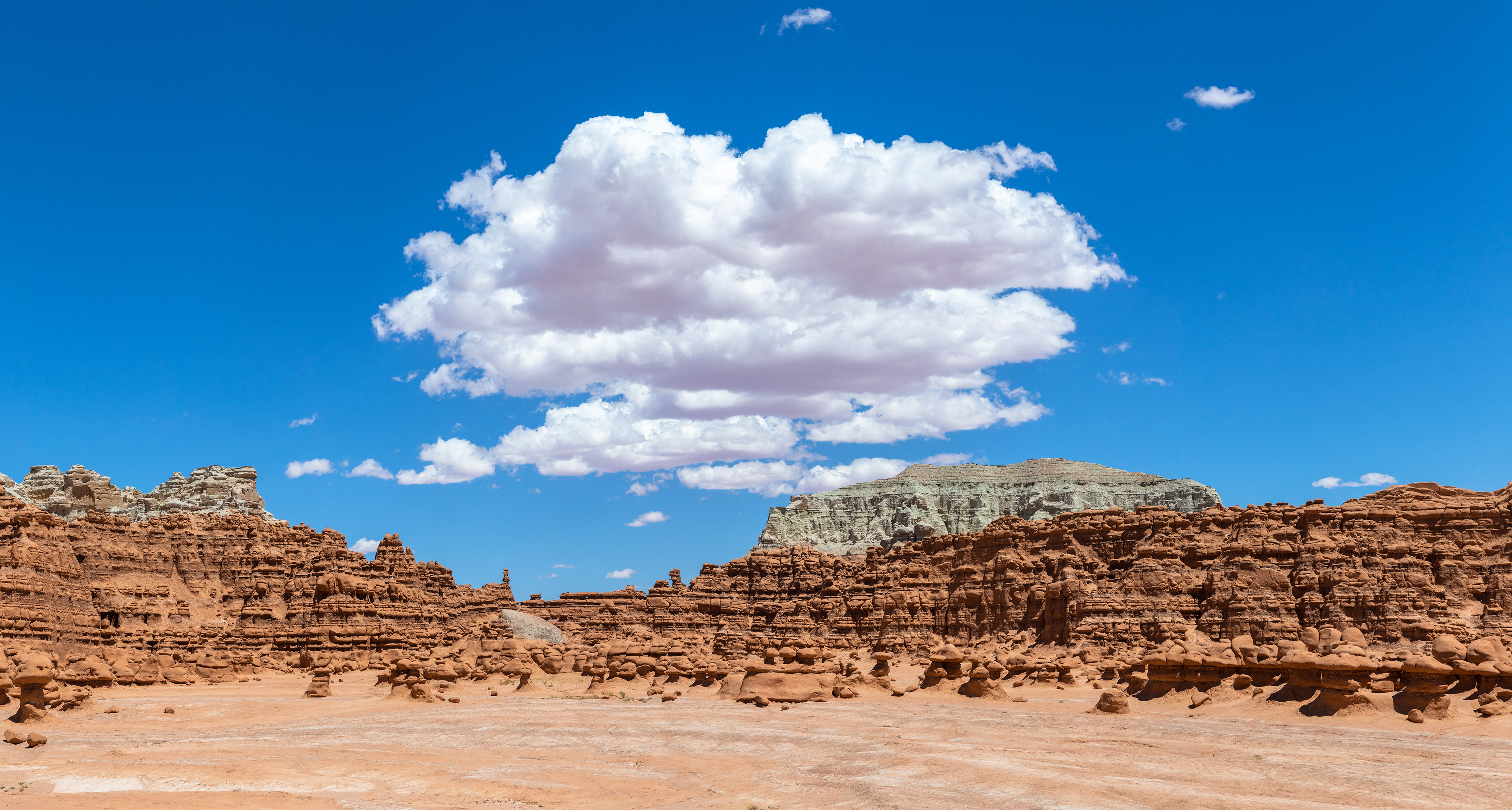 A lone cloud stands watch in the sky over Goblin Valley State Park, UT