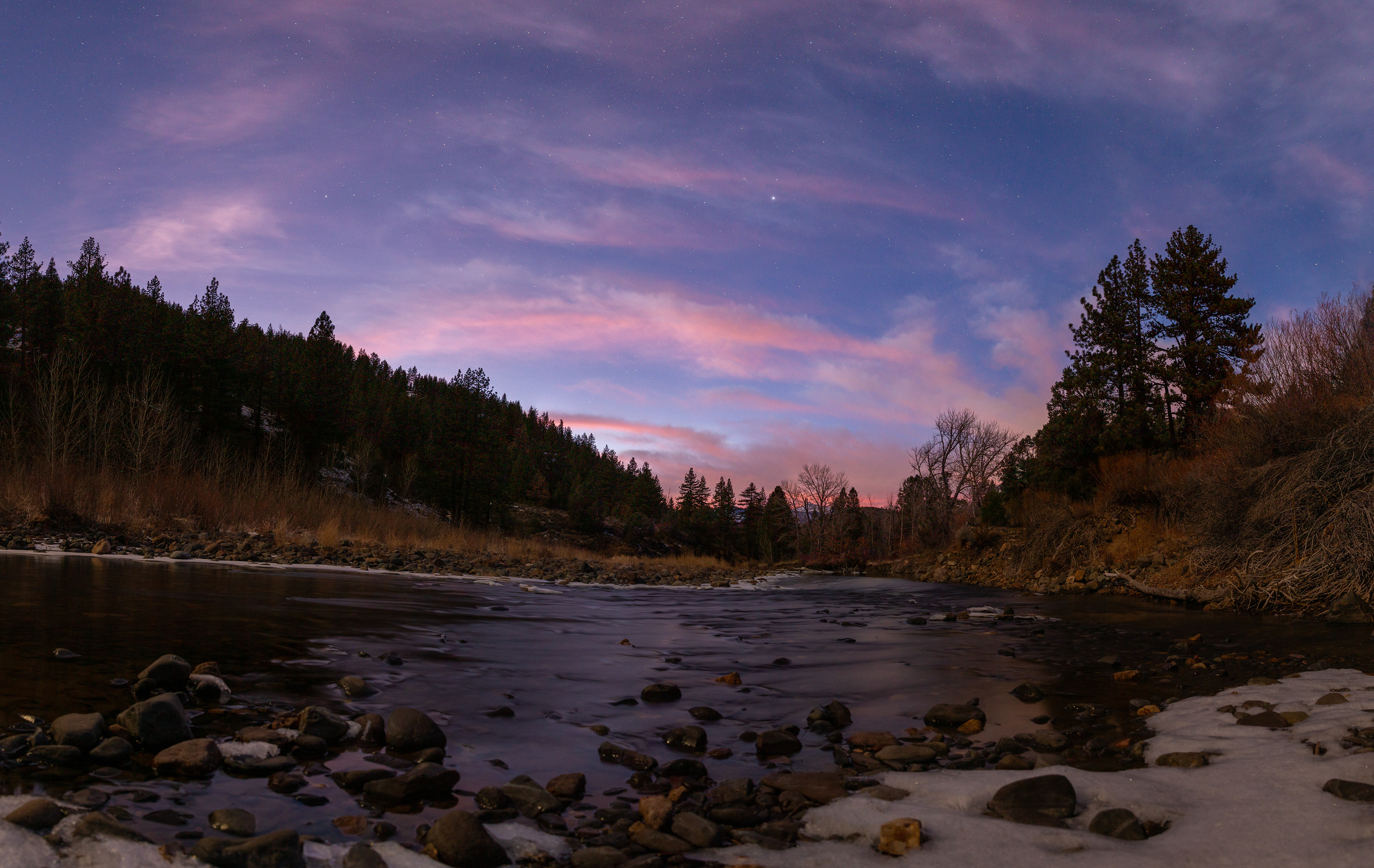 The setting sun uses the last of its light to color the night sky over this icy river outside Reno, NV.