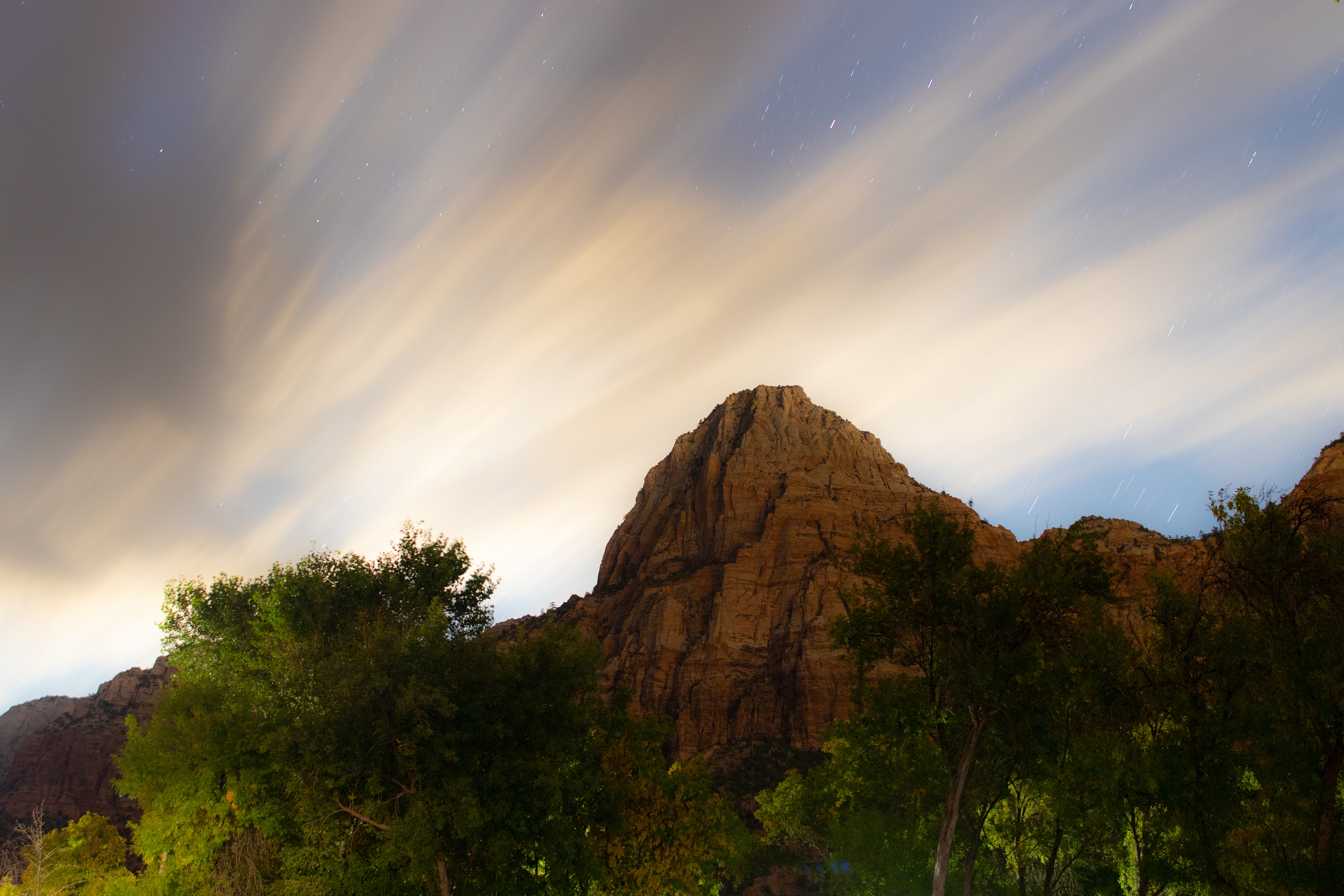 The night sky streaks its clouds and stars over Zion NP, UT.