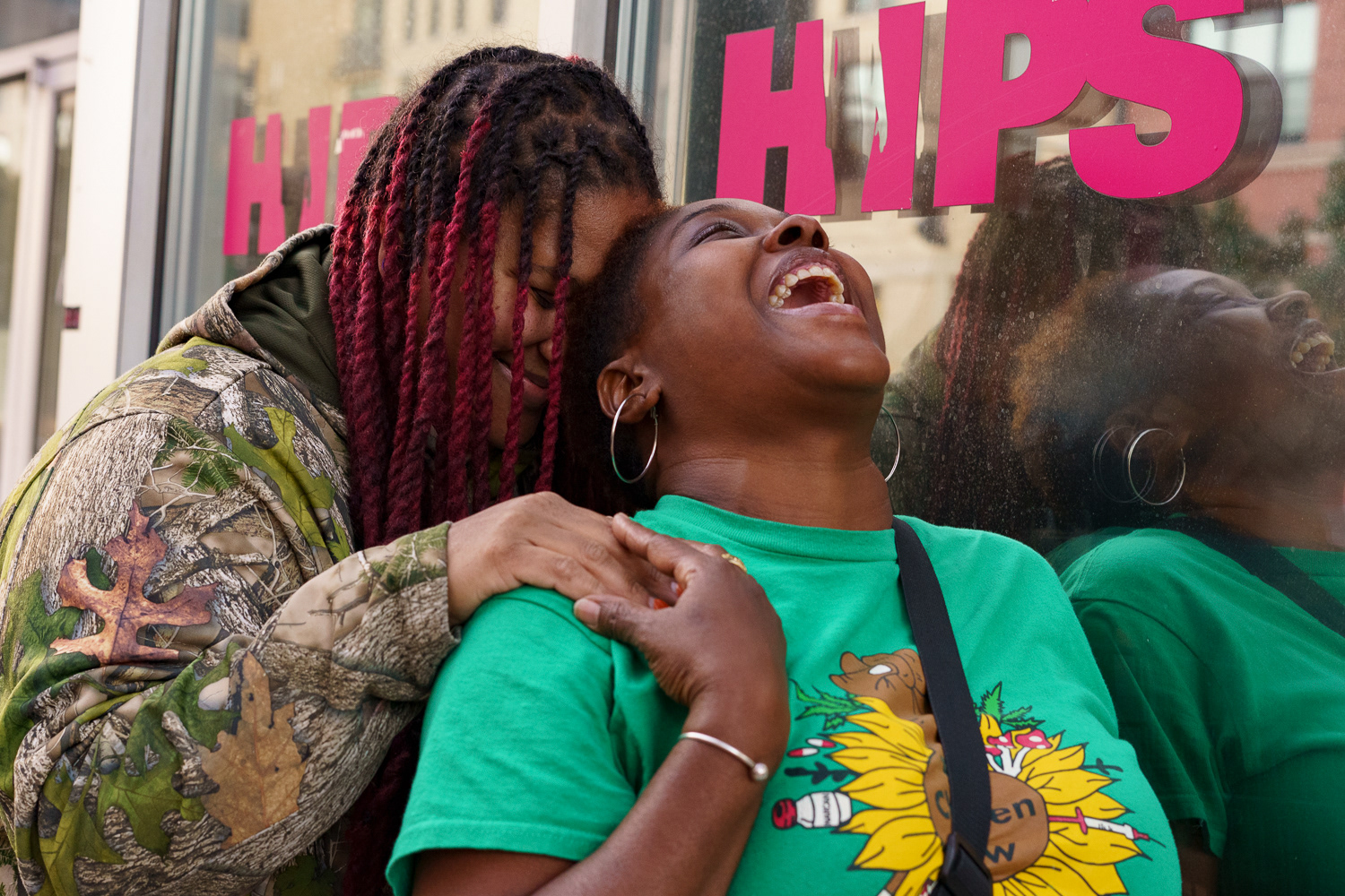 Nkeiru and Phoenix hold each other in a laughing embrace outside HIPS, 906 H St. NE.