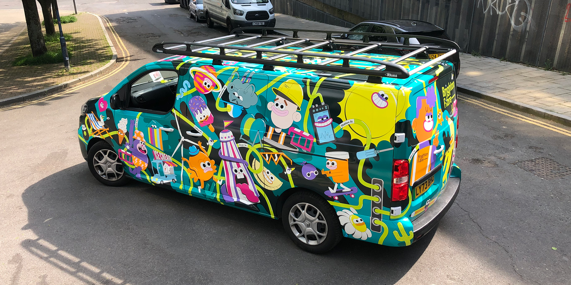 Photo of Brighton Fibre's street team van. The van is wrapped in colourful character illustrations, with A Brighton and Hove theme,  designed by Chloe Studios.