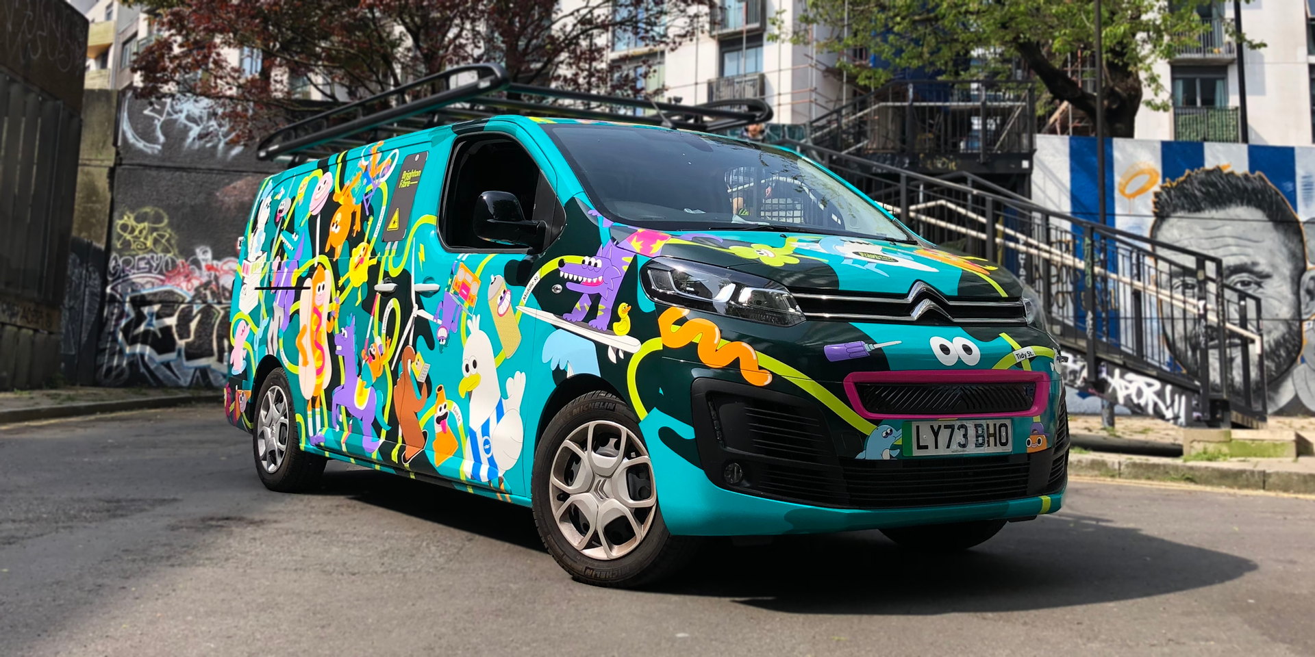 Photo of Brighton Fibre's street team van. The van is wrapped in colourful character illustrations, with A Brighton and Hove theme,  designed by Chloe Studios.