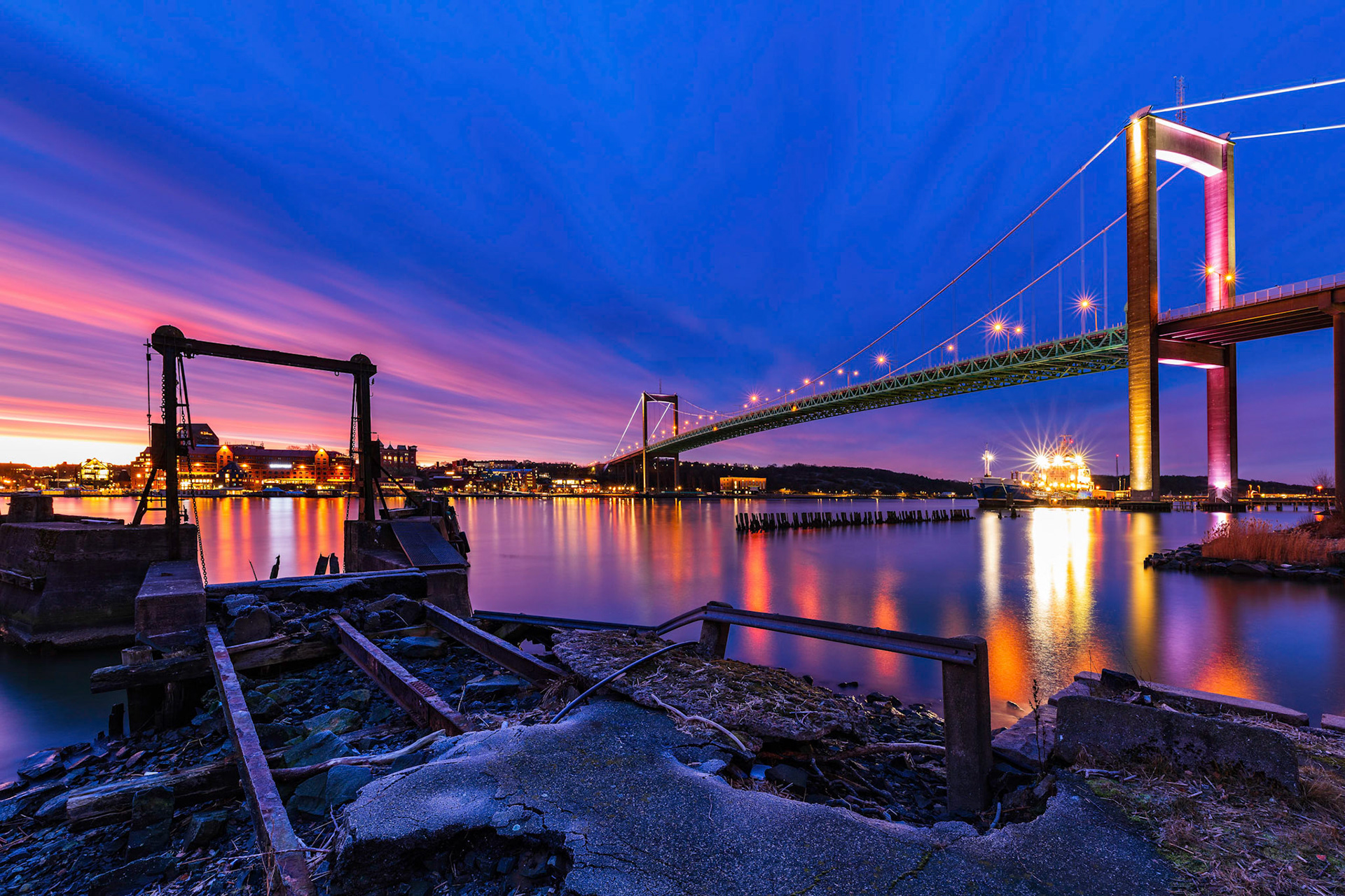 View from riverside of illuminated bridge at sunset, Gothenburg, Sweden, Europe