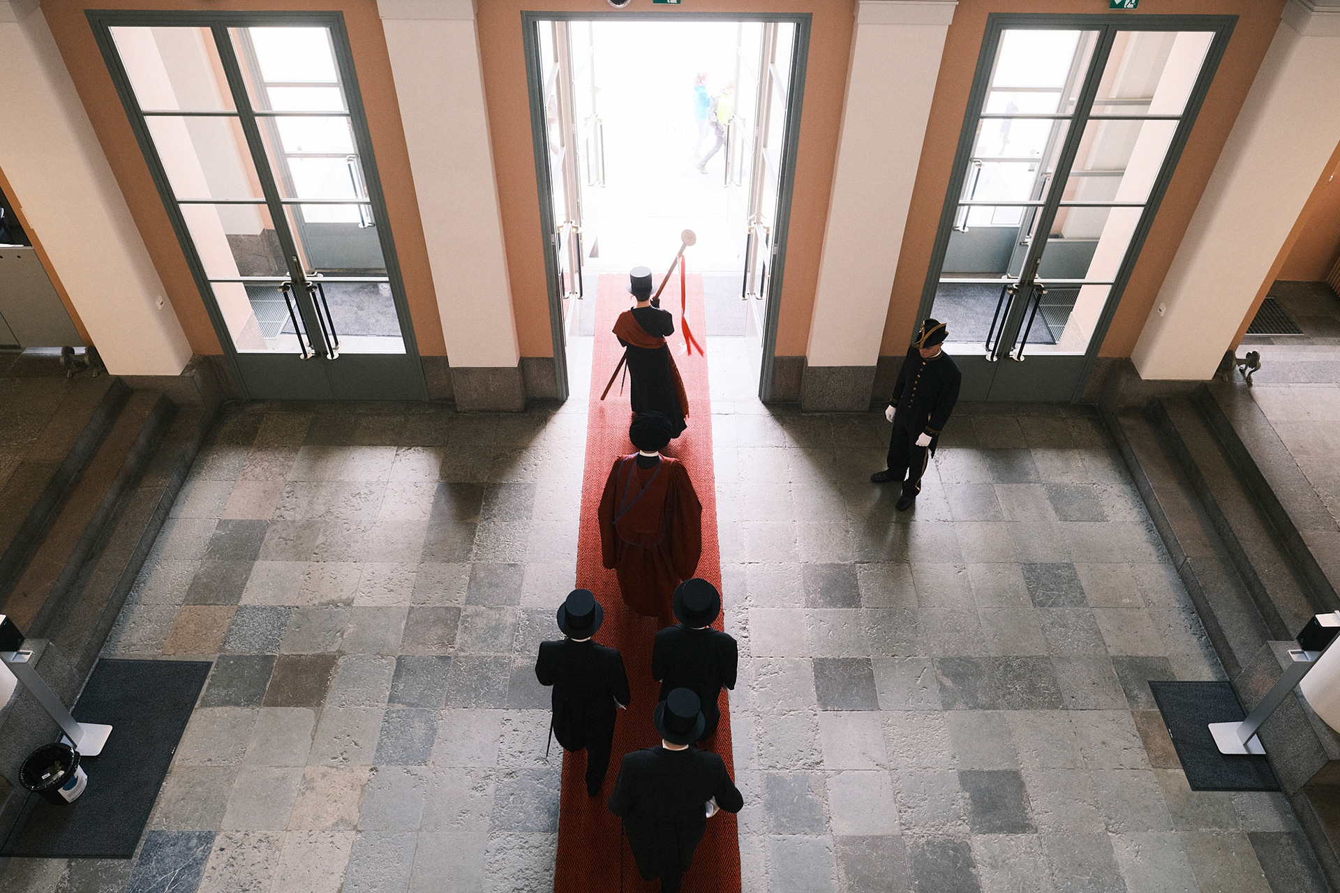 Promootiokulkue poistumassa Helsingin yliopiston päärakennuksen pääovista. Valtiotieteellisen tiedekunnan XV promootio, 2022.