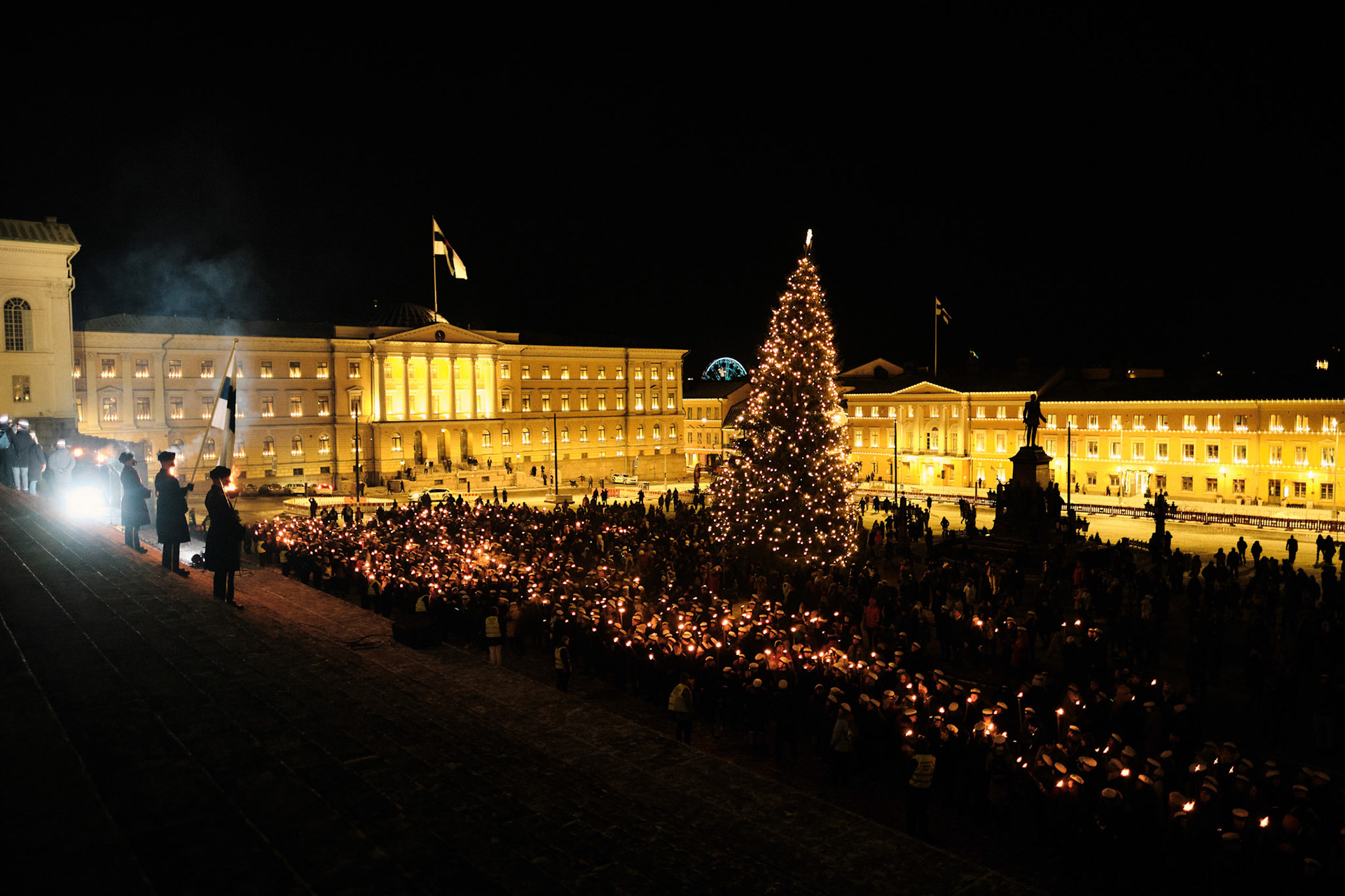 Opiskelijoiden perinteinen soitukulkue saapui Helsingin Senaatintorille itsenäisyyspäivänä 2023. Senaatintorin portailla Suomen lippua kantavia Maanpuolustuskorkeakoulun kadetteja.