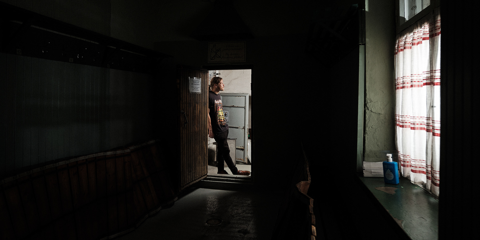 Rajaportin saunan isännöitsijä Ilmari Lyymä poseeraa miesten pukuhuoneen ovella. Rajaportti on Suomen vanhin yhä toiminnassa oleva julkinen sauna.