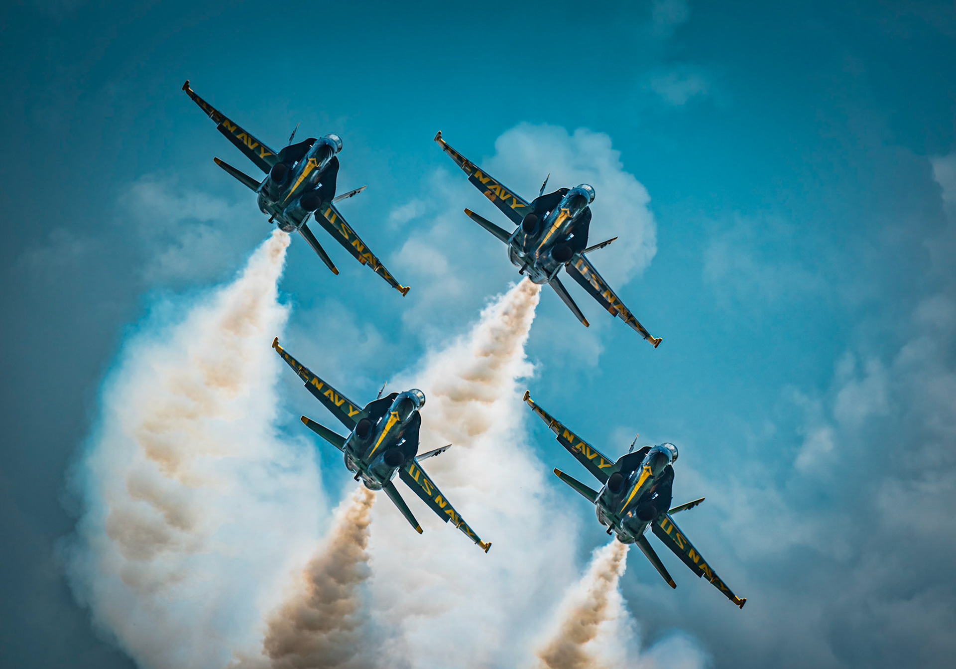 4 Blue Angel jets perform in formation at an air show.