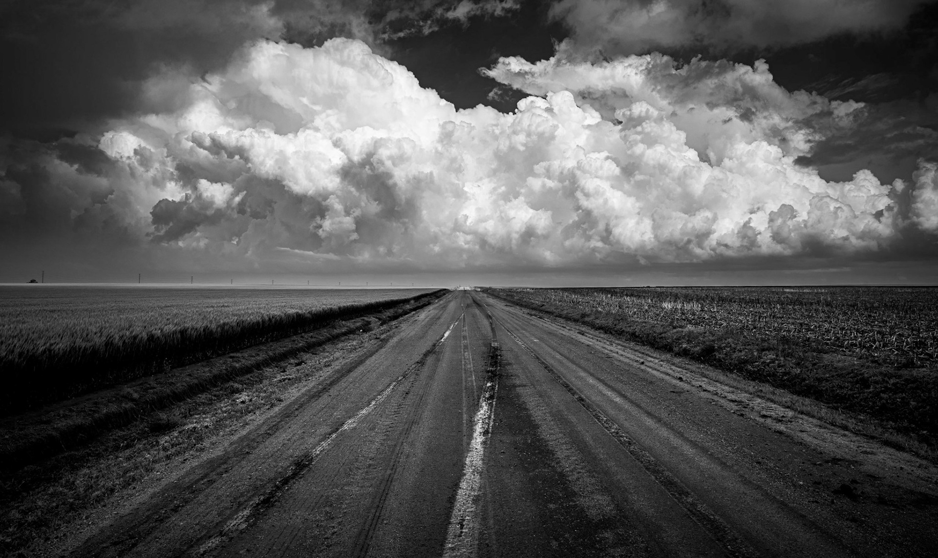 Looking down a muddy road towards a building storm.