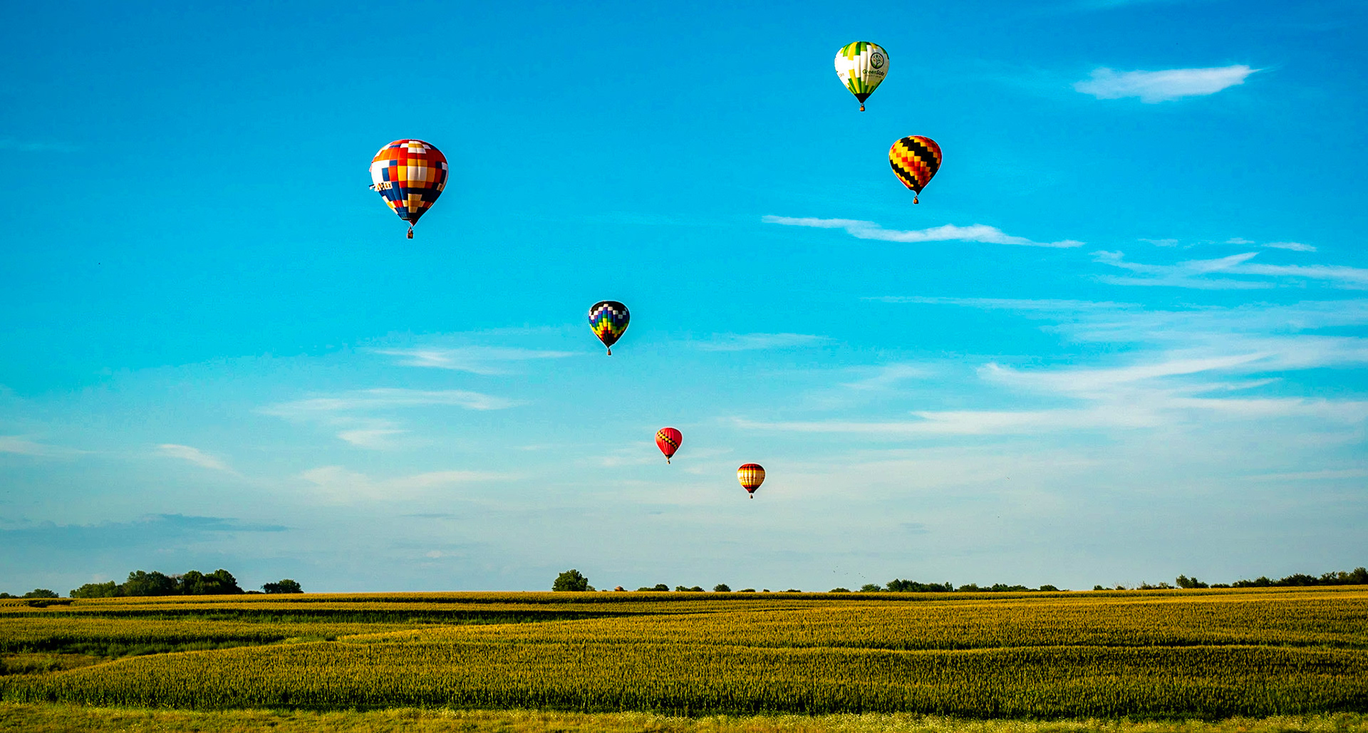 Hot air ballloons floating over the Iowa Countryside.