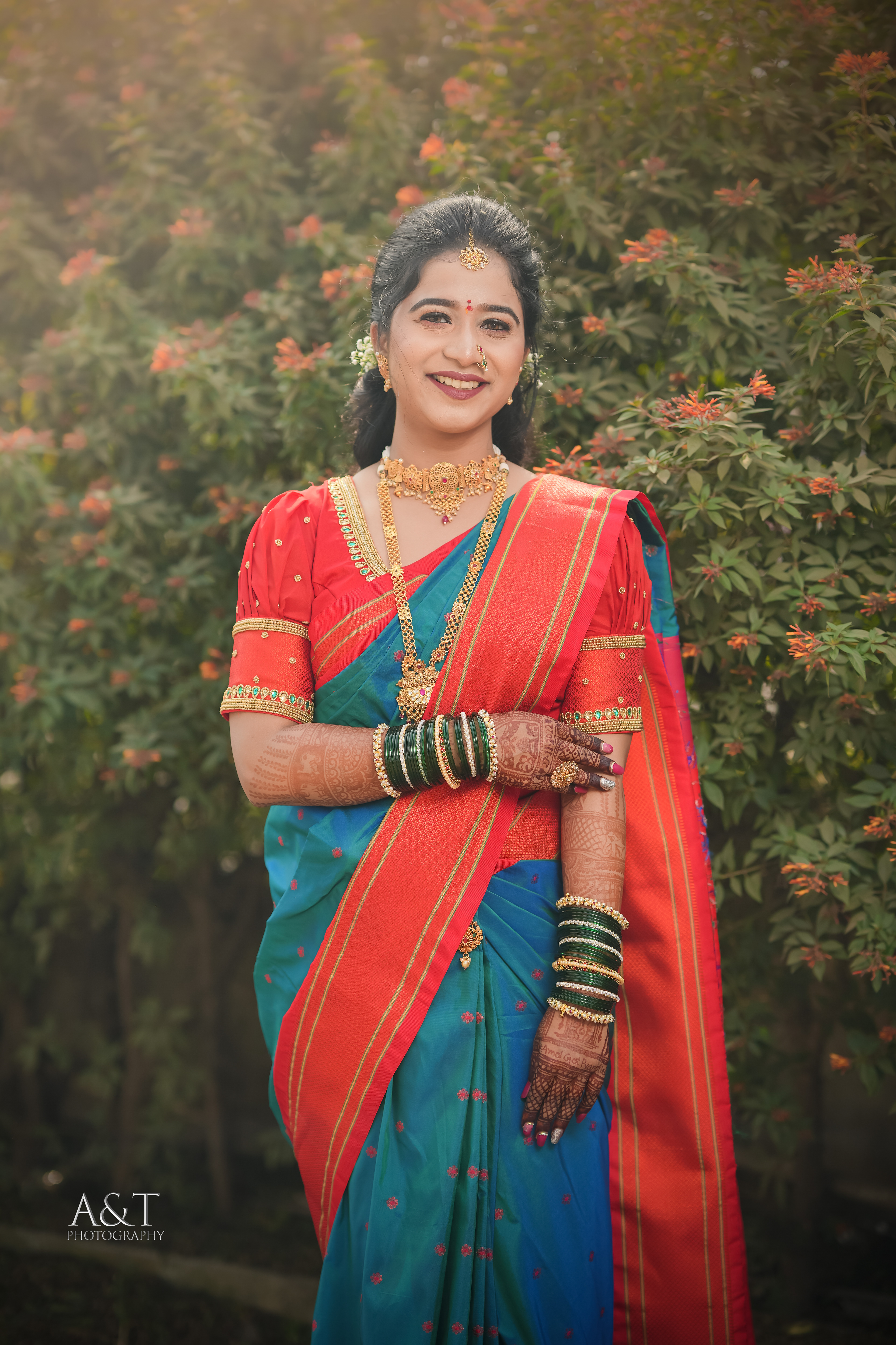 The rich red hues of the Paithani saree enhance the Maharashtrian bride's captivating presence