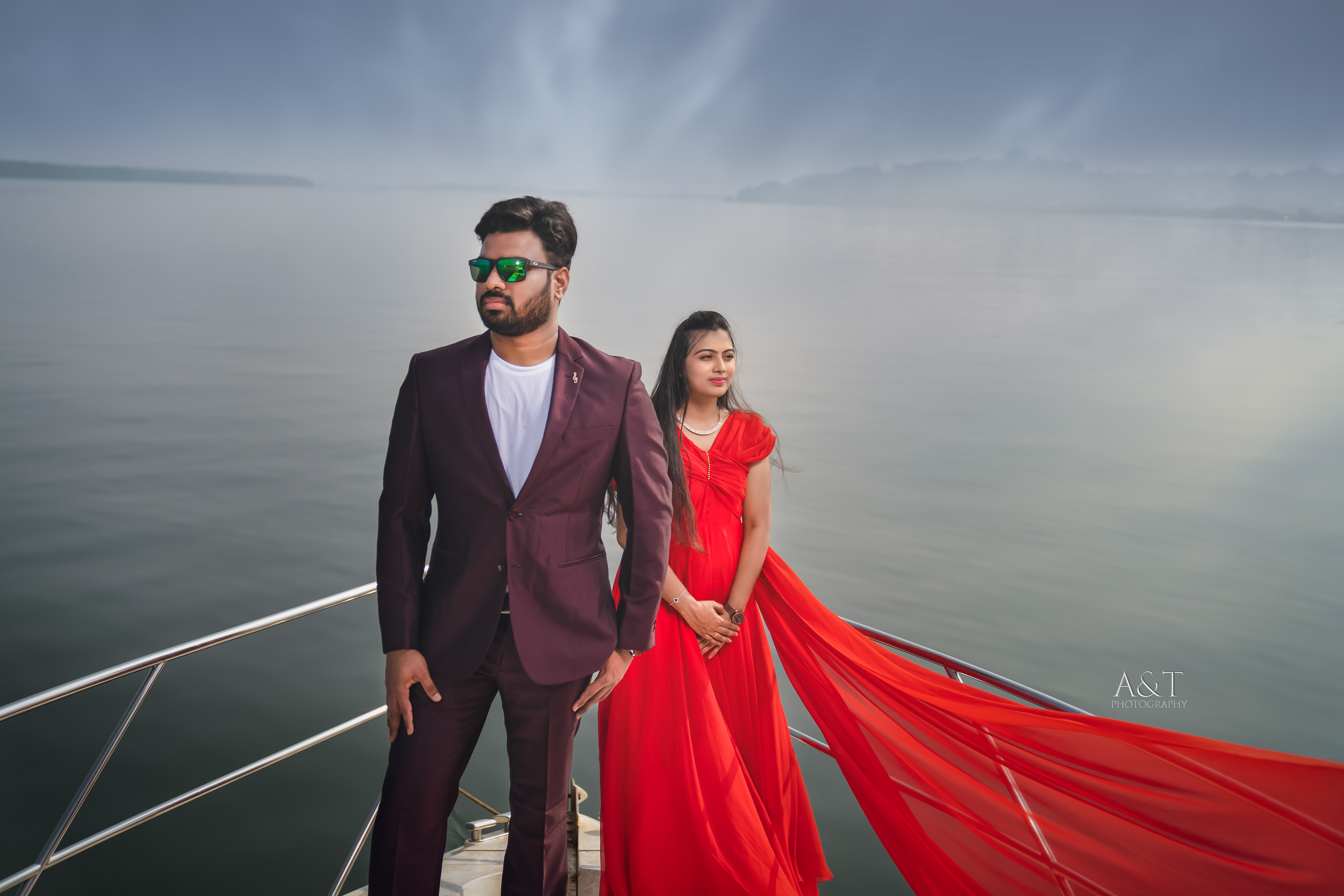 Santosh & Manasvi standing on a yacht, embracing each other with the sea in the background. Captured beautifully by best pre-wedding photographer in Goa