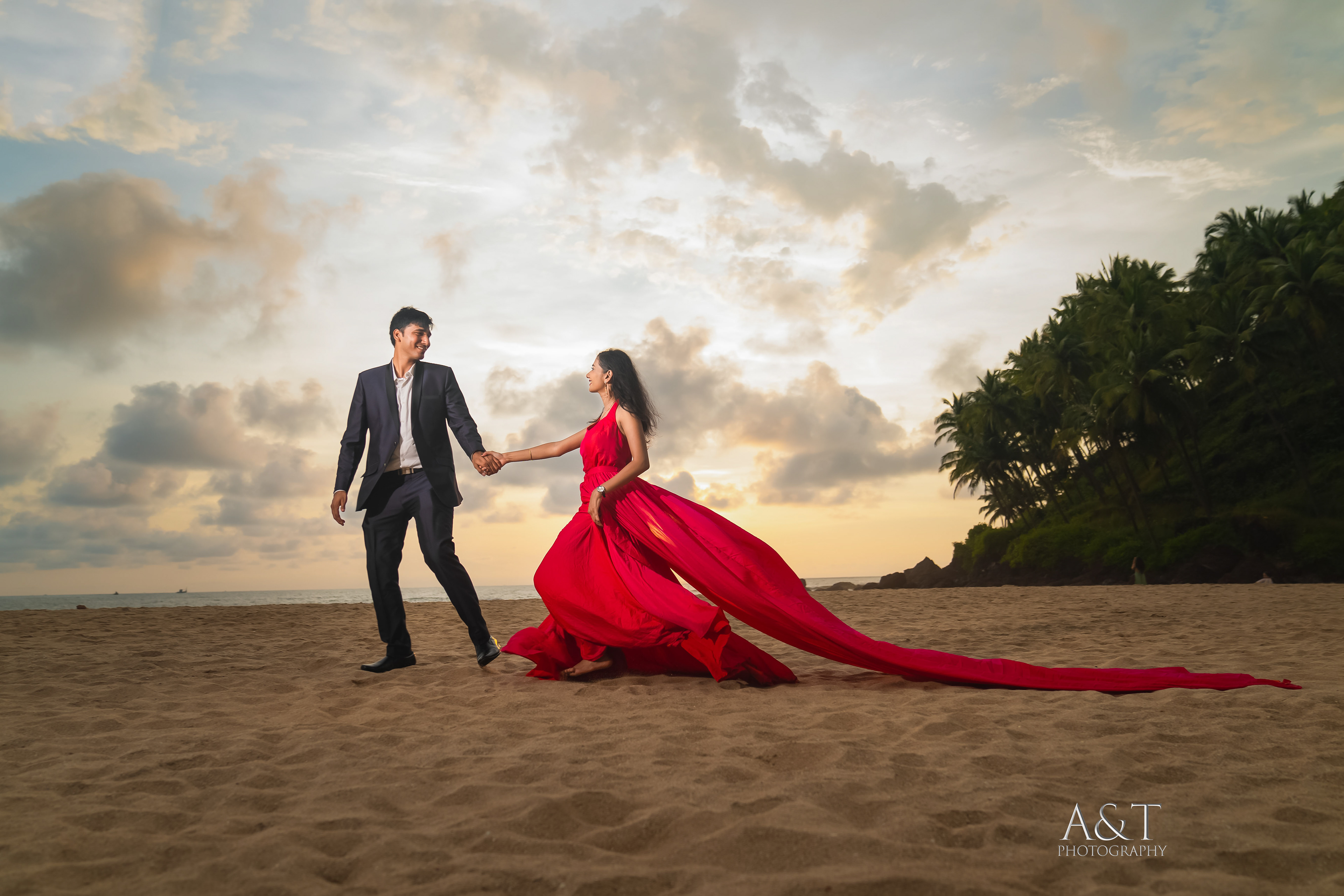 Romantic couple holding hands as they walk on a golden beach at sunset in Goa, India| A&T Photography-Best Pre wedding photographer in Goa
